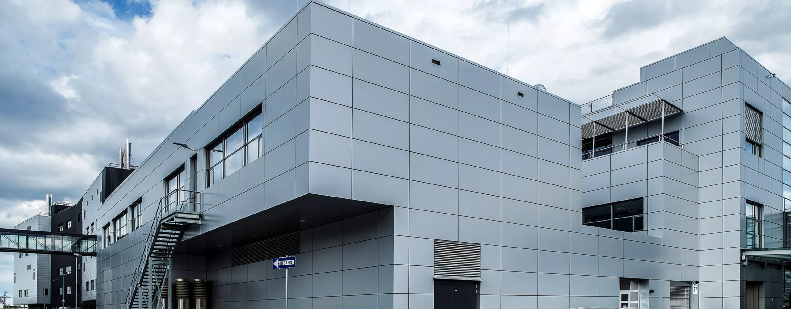 Ein dunkelblauer BMW 2er Active Tourer fährt über das Industriegelände des BMW Group Werk Steyr. 