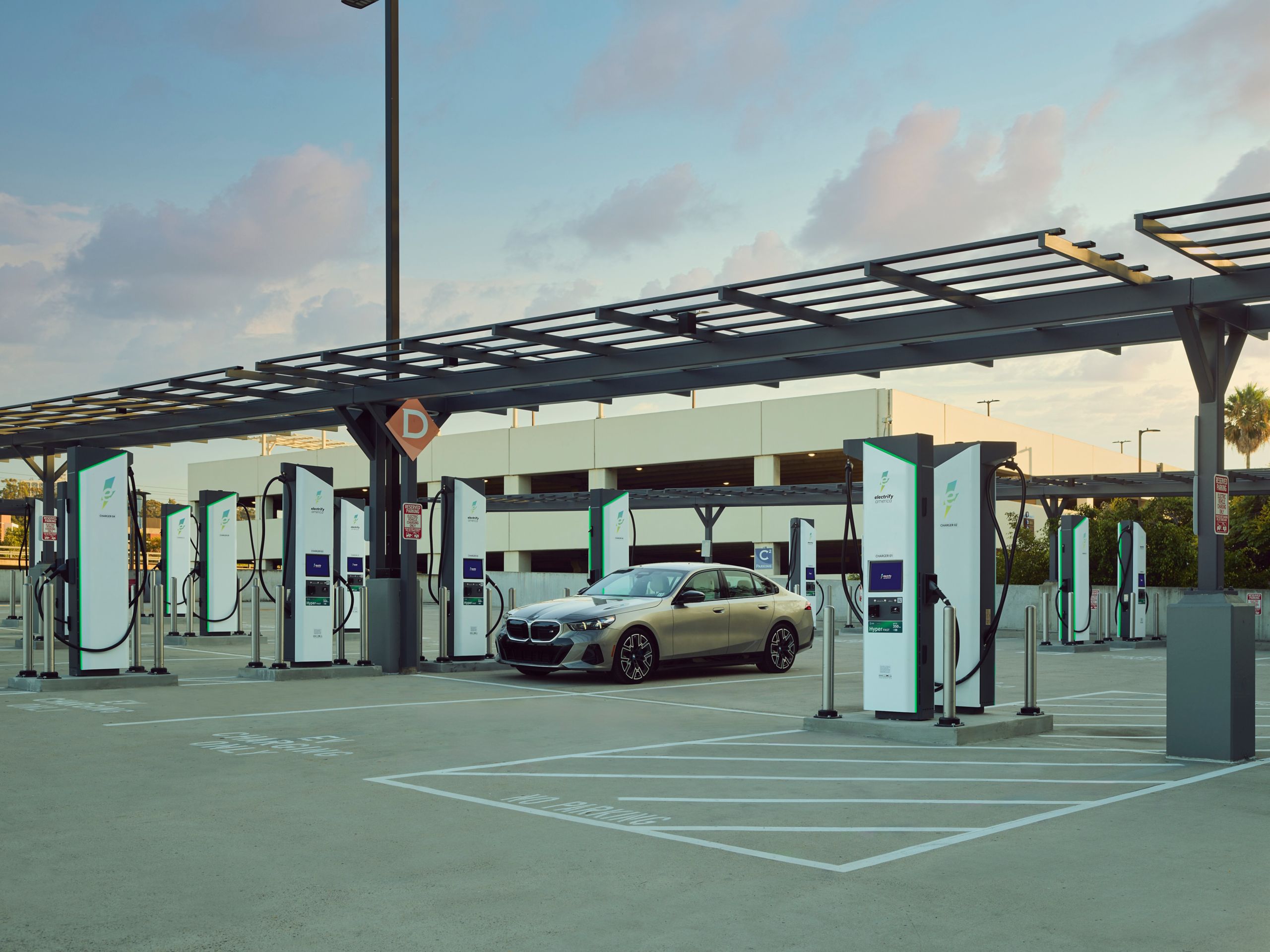 A BMW i5 parked at an Electrify America station