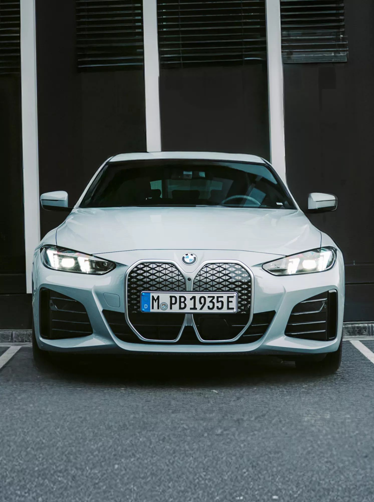 BMW i4, паркиран фронтално на маркирано място пред сграда