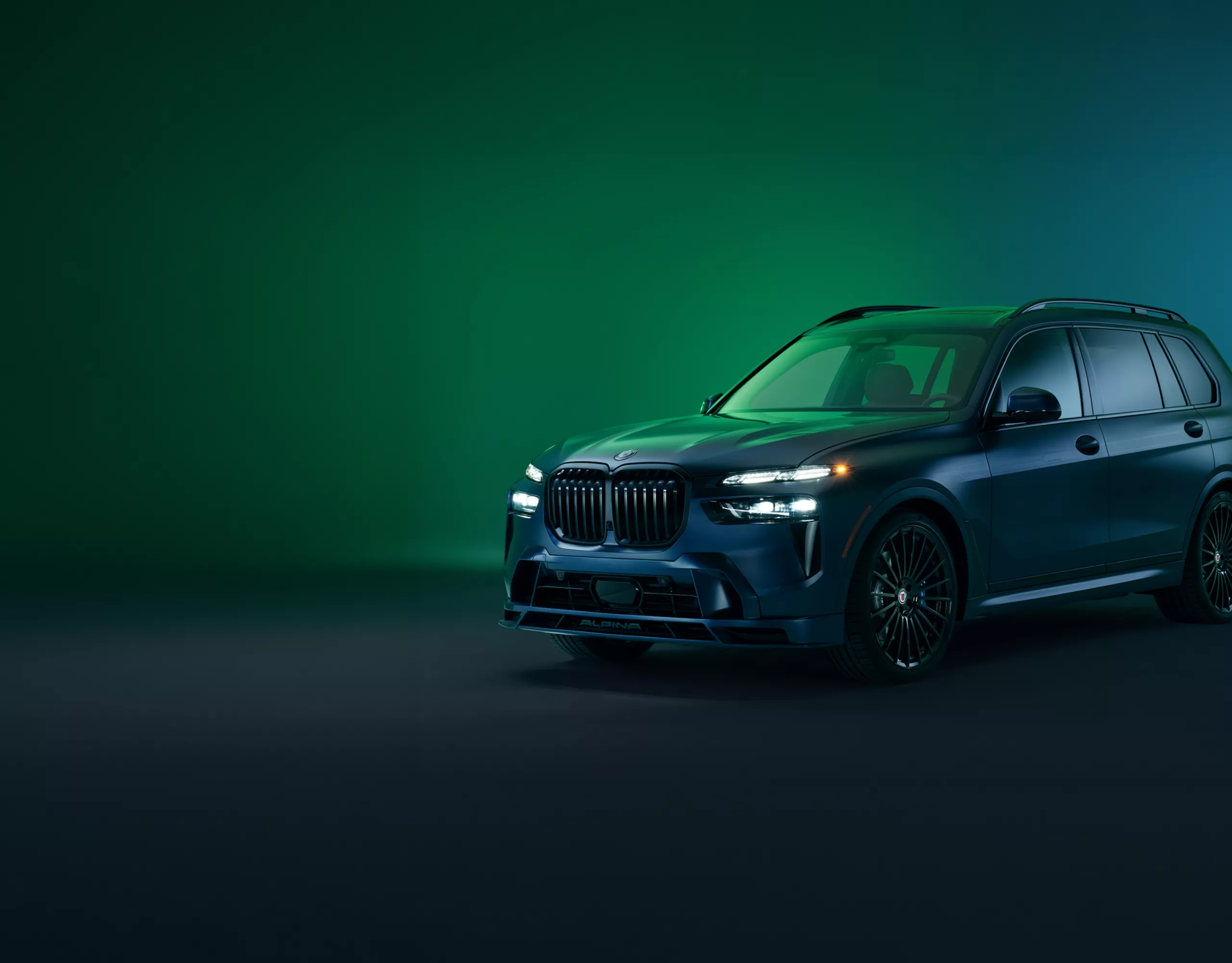 A BMW iX3 is parked in a designated parking zone at the curb, which is lined by plants 