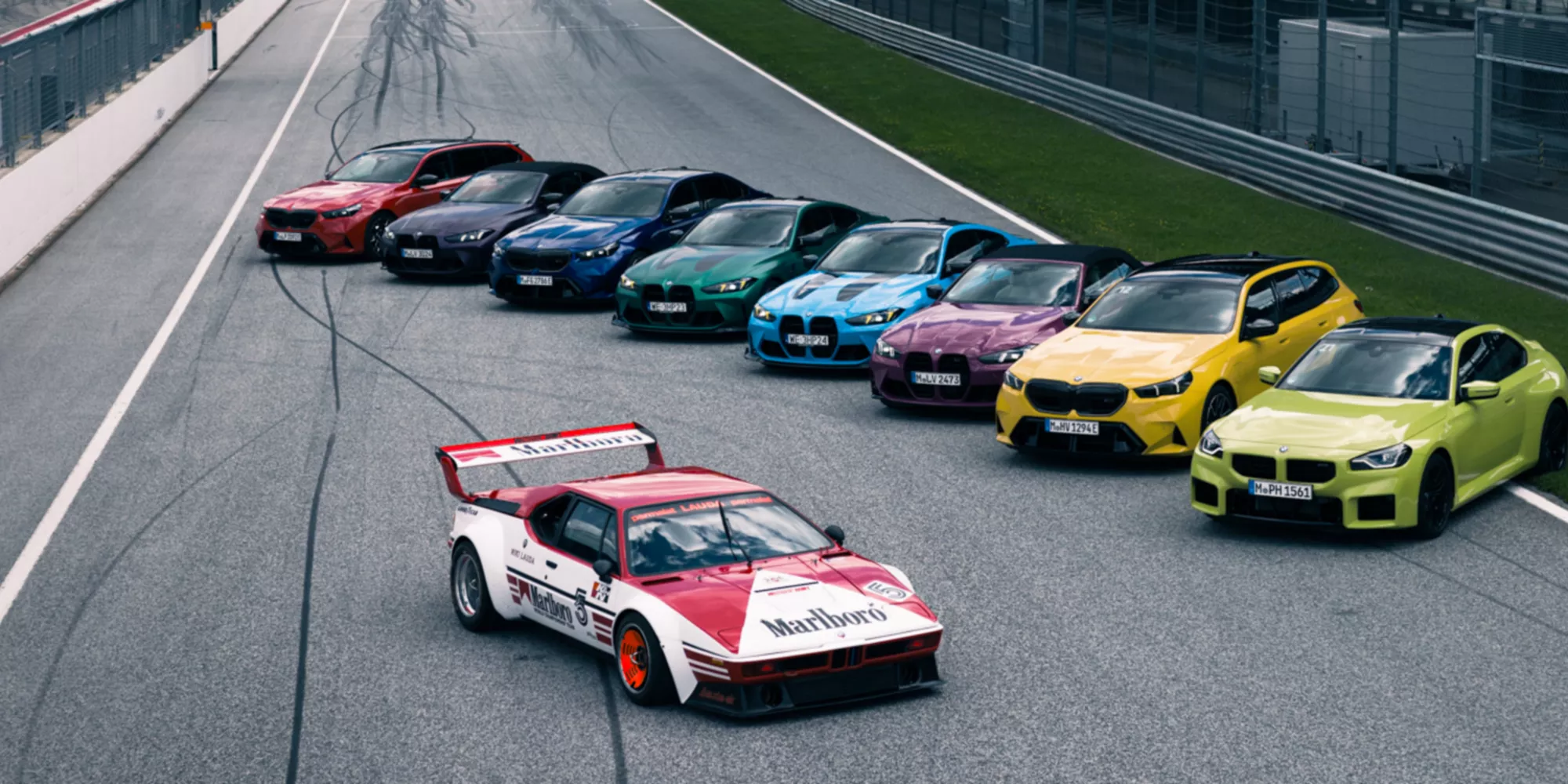 Eine BMW i3 Limousine fährt auf einer kurvigen Serpentinenstraße durchs Gebirge