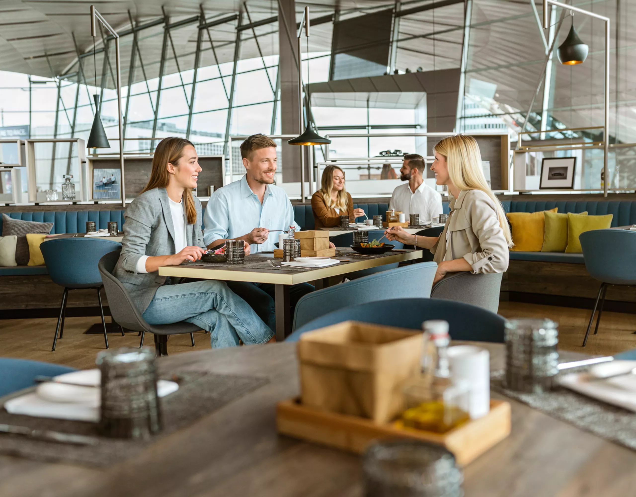 Two women and a man enjoy food in the Bavarie at BMW Welt