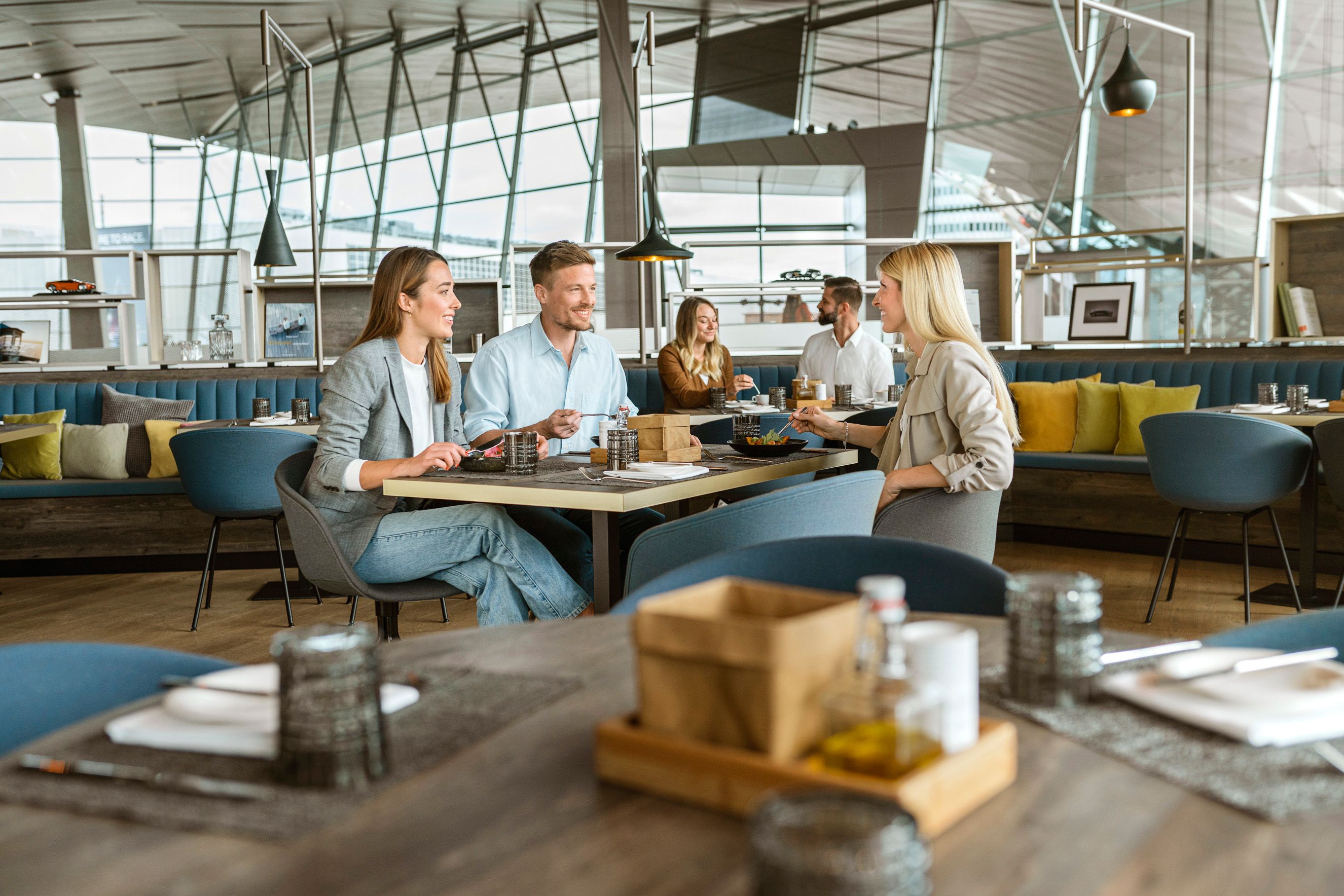 Two women and a man enjoy food in the Bavarie at BMW Welt