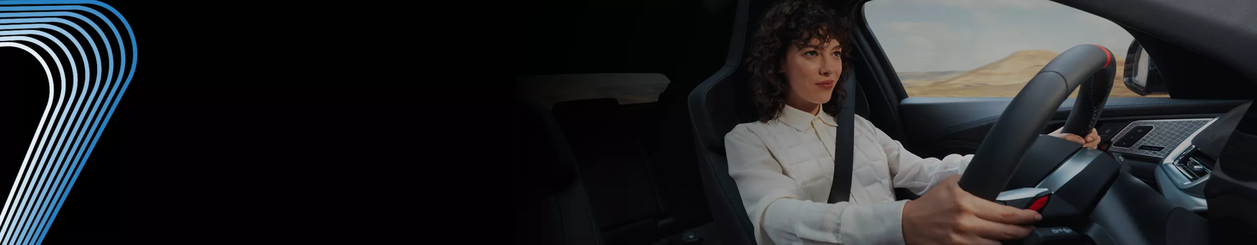 A dramatic closeup of a woman with a determined expression gripping the steering wheel of a BMW 