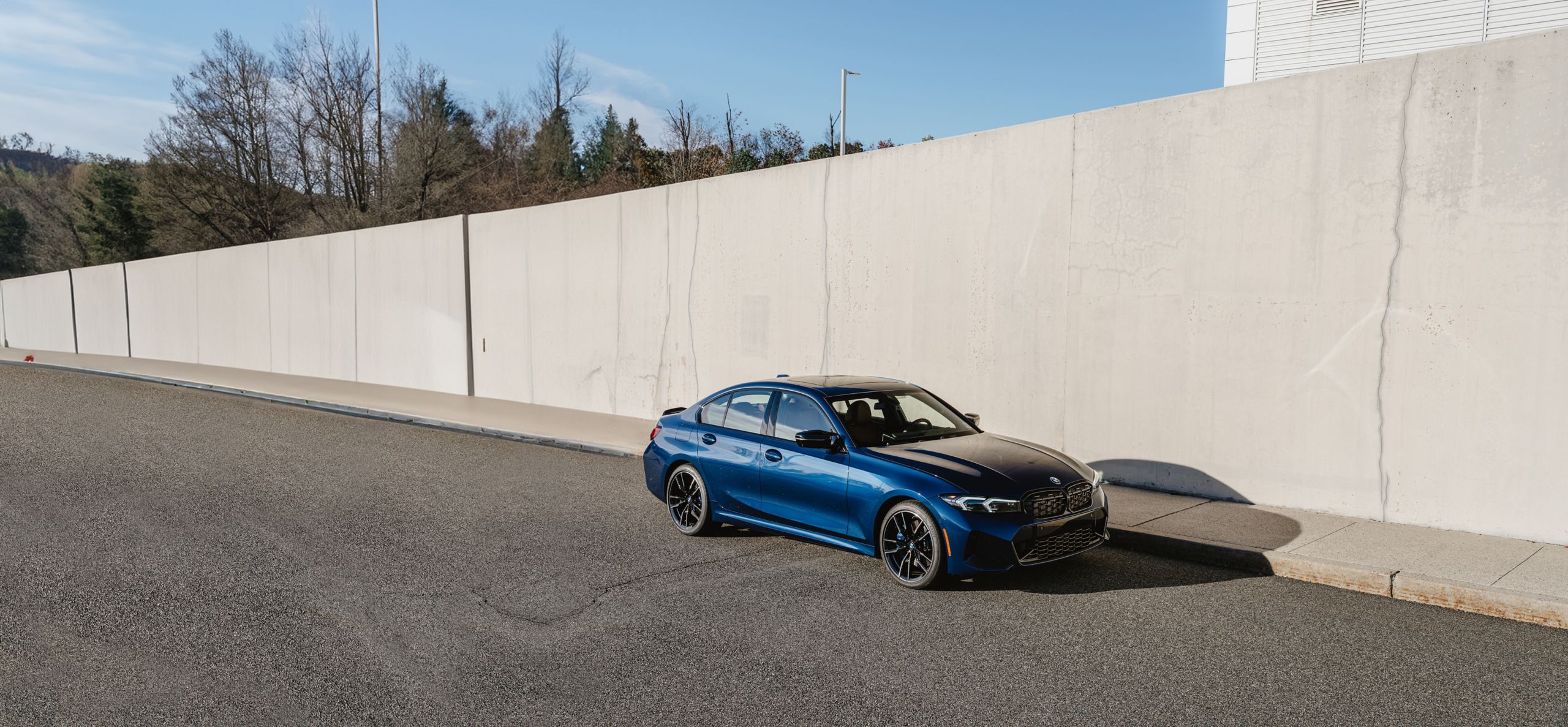 Side angle shot of a BMW M340i xDrive 50 Jahre Edition in BMW Individual Avus Blue Metallic paint finish