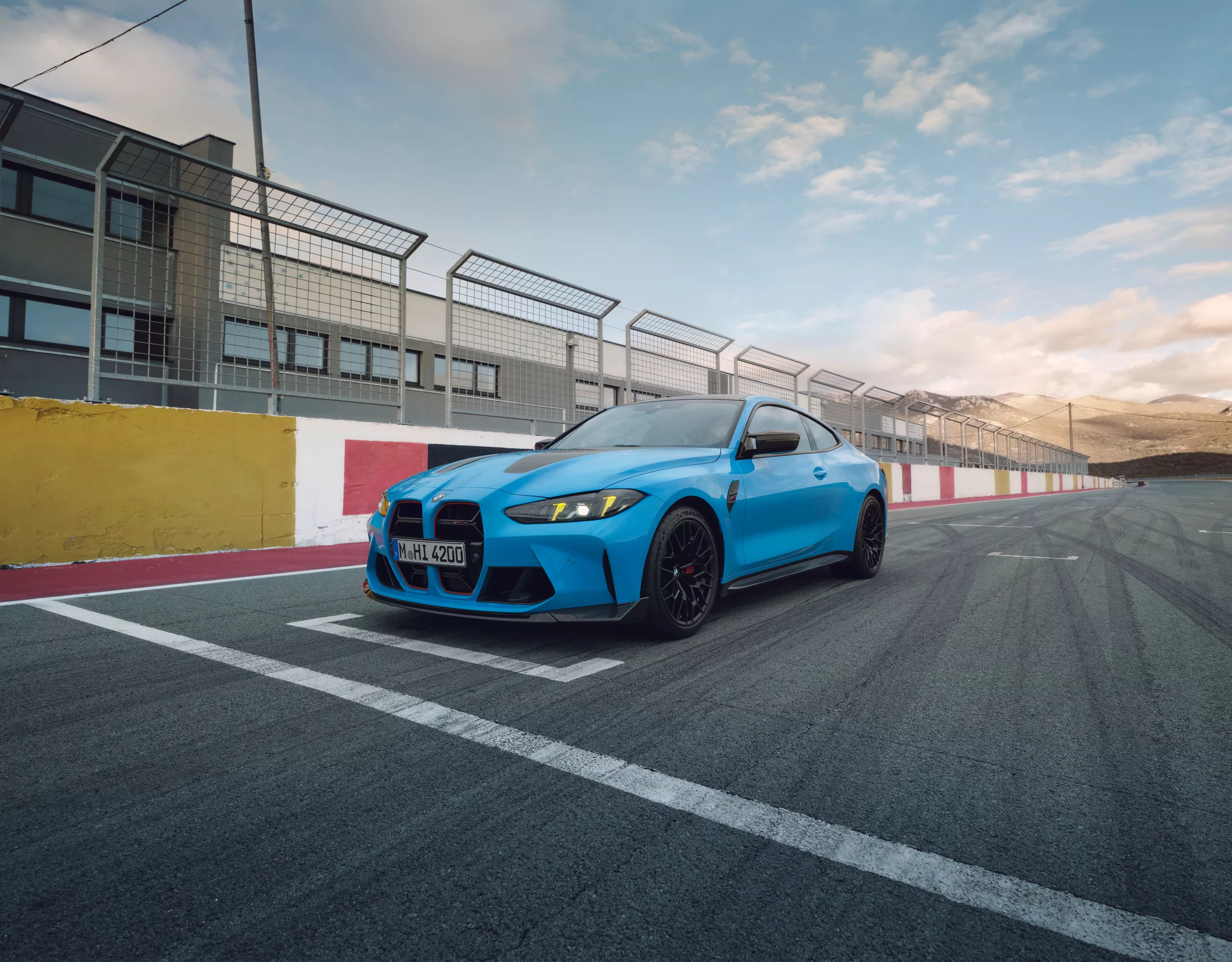 Niebieskie BMW M4 CS w przyciągającym wzrok, eksrawaganckim kolorze niebieskim, na torze.