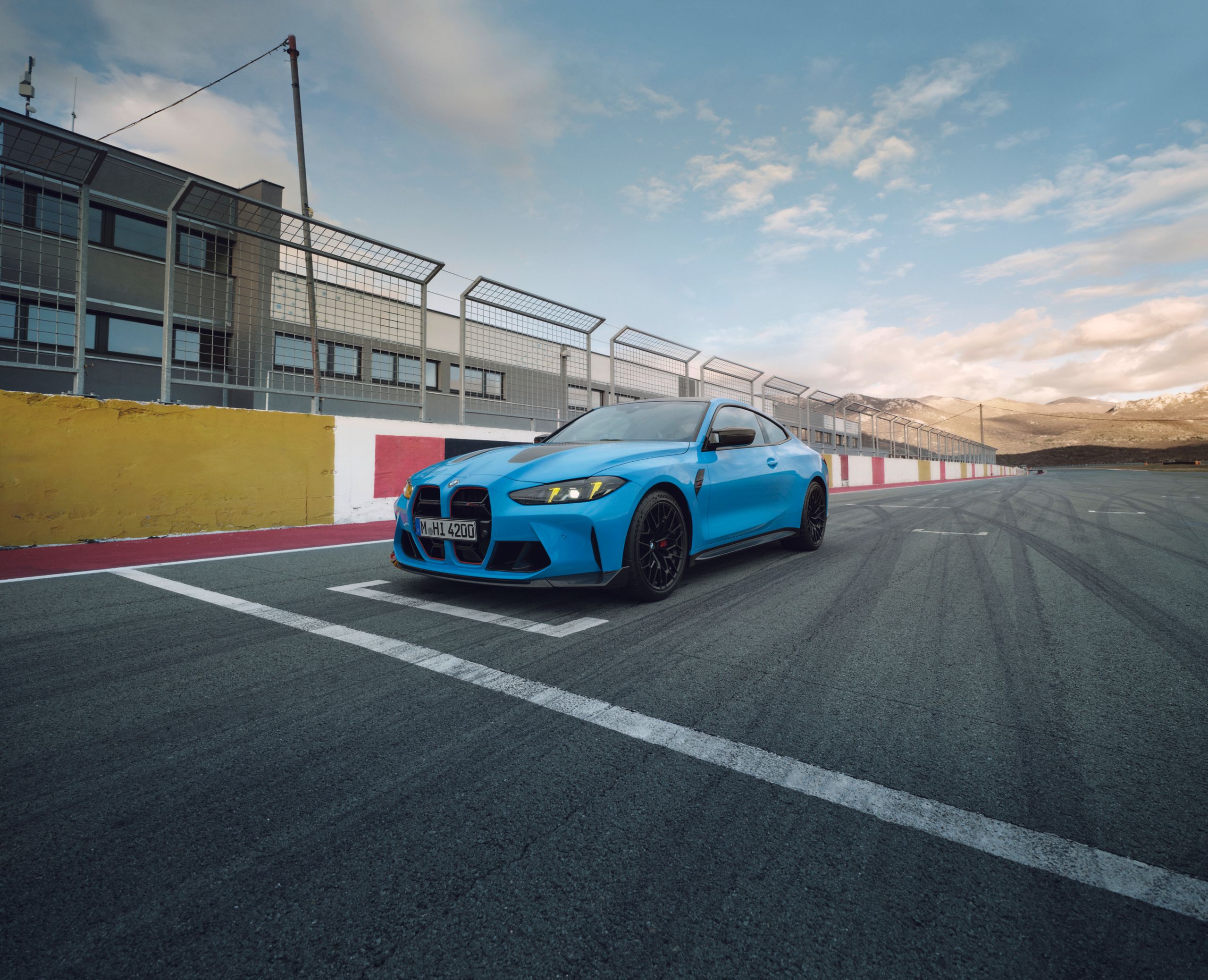 Niebieskie BMW M4 CS w przyciągającym wzrok, eksrawaganckim kolorze niebieskim, na torze.