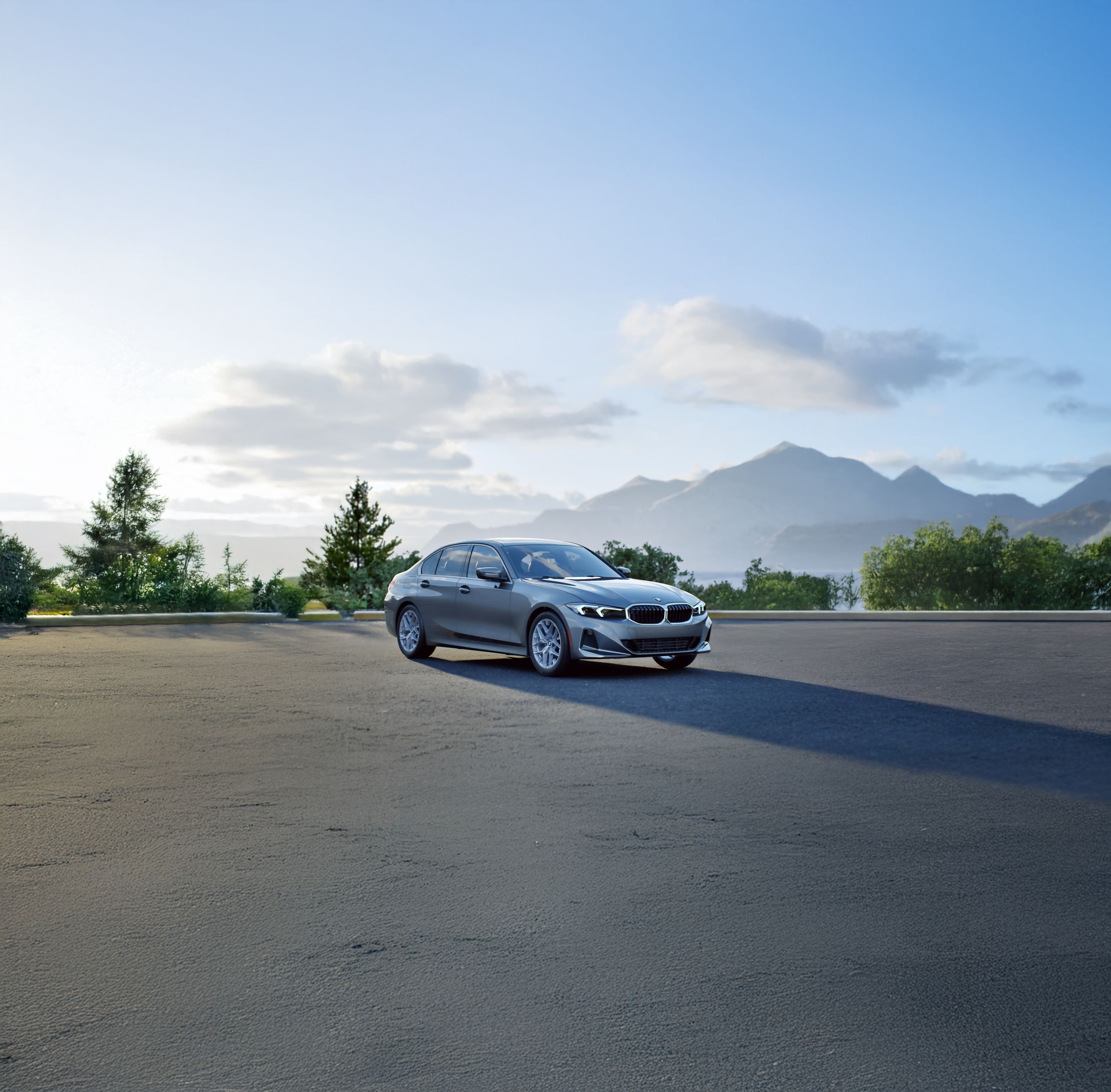 A BMW 330 xDrive Sedan parked in a scenic lot with pine trees and mountains in the background