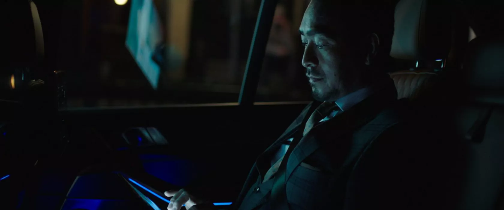 Man riding in back of BMW at night