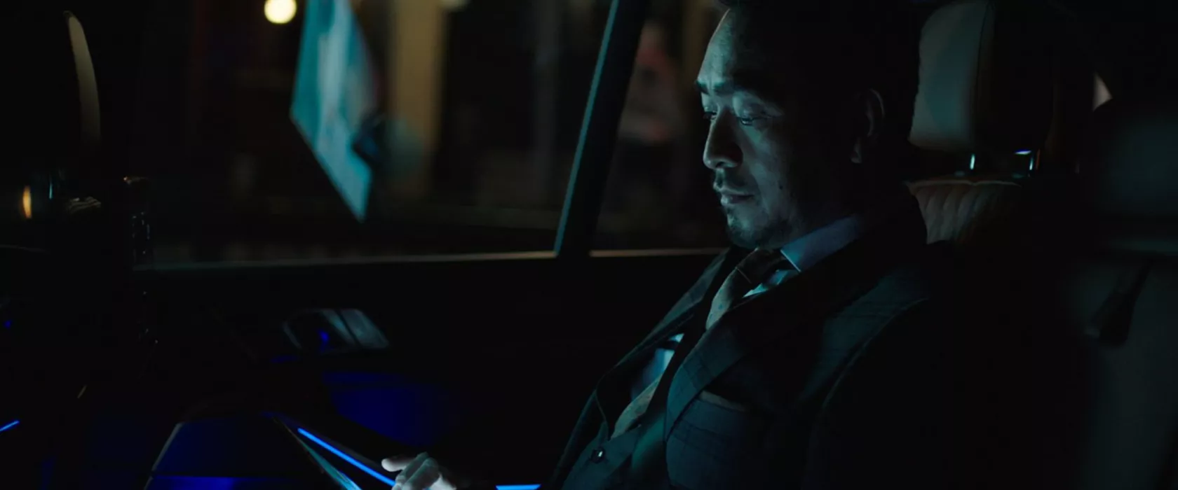 Man riding in back of BMW at night