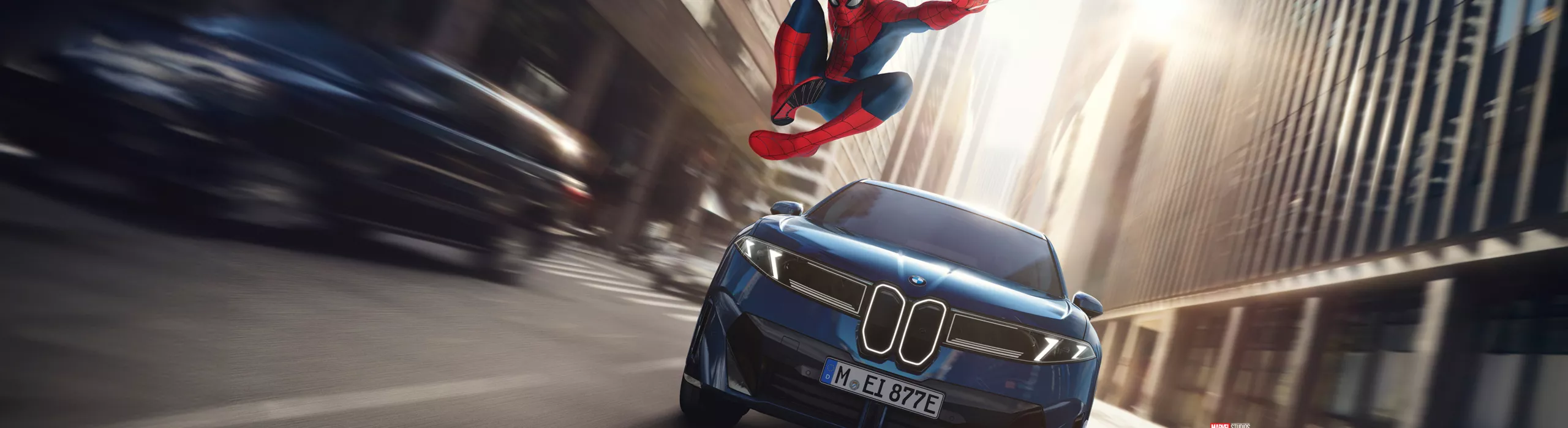 Spider‑Man in heldenhafter Pose neben dem BMW iX3.
