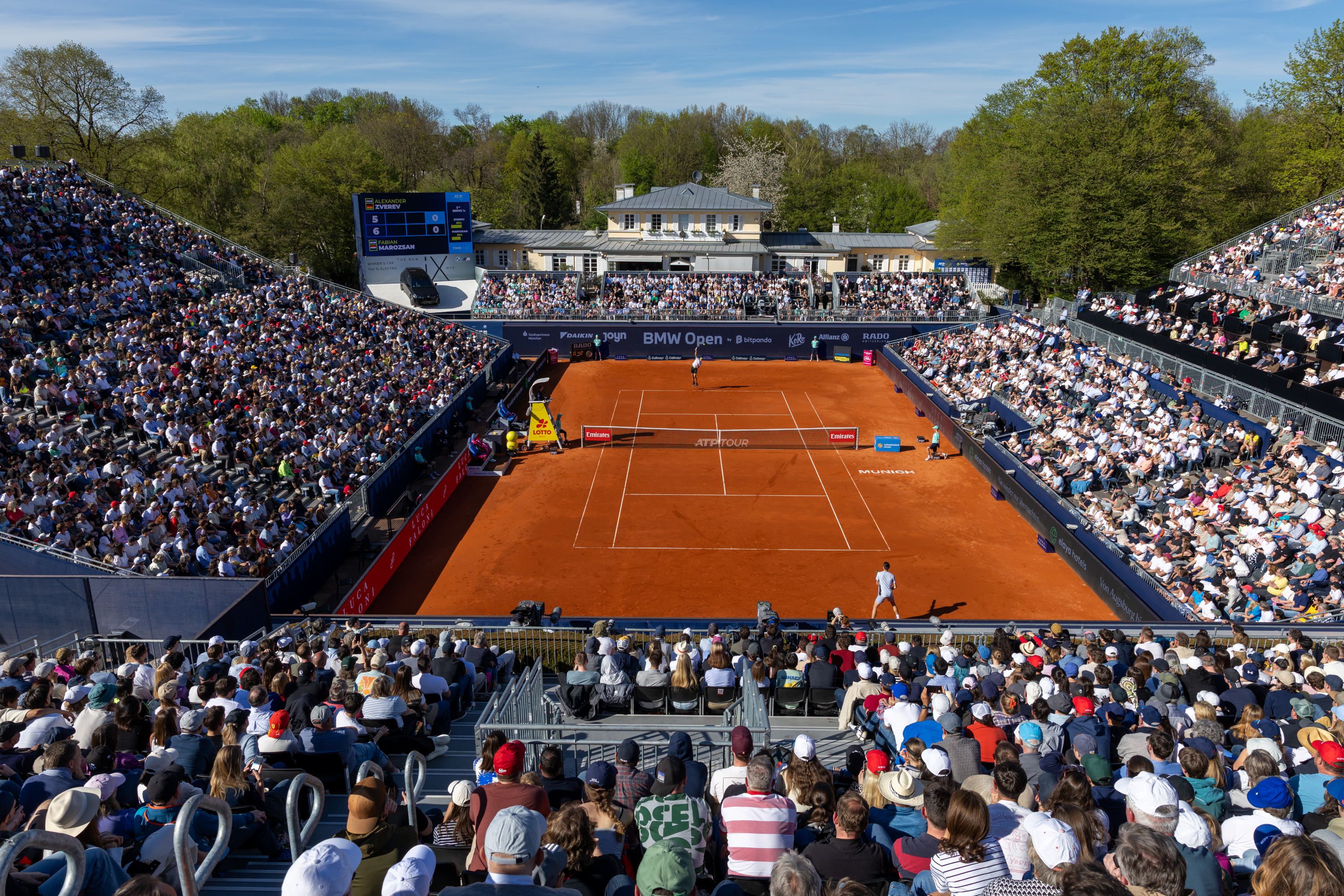 BMW iX3 steht parkend vor einem Gebäude mit Glasfassade