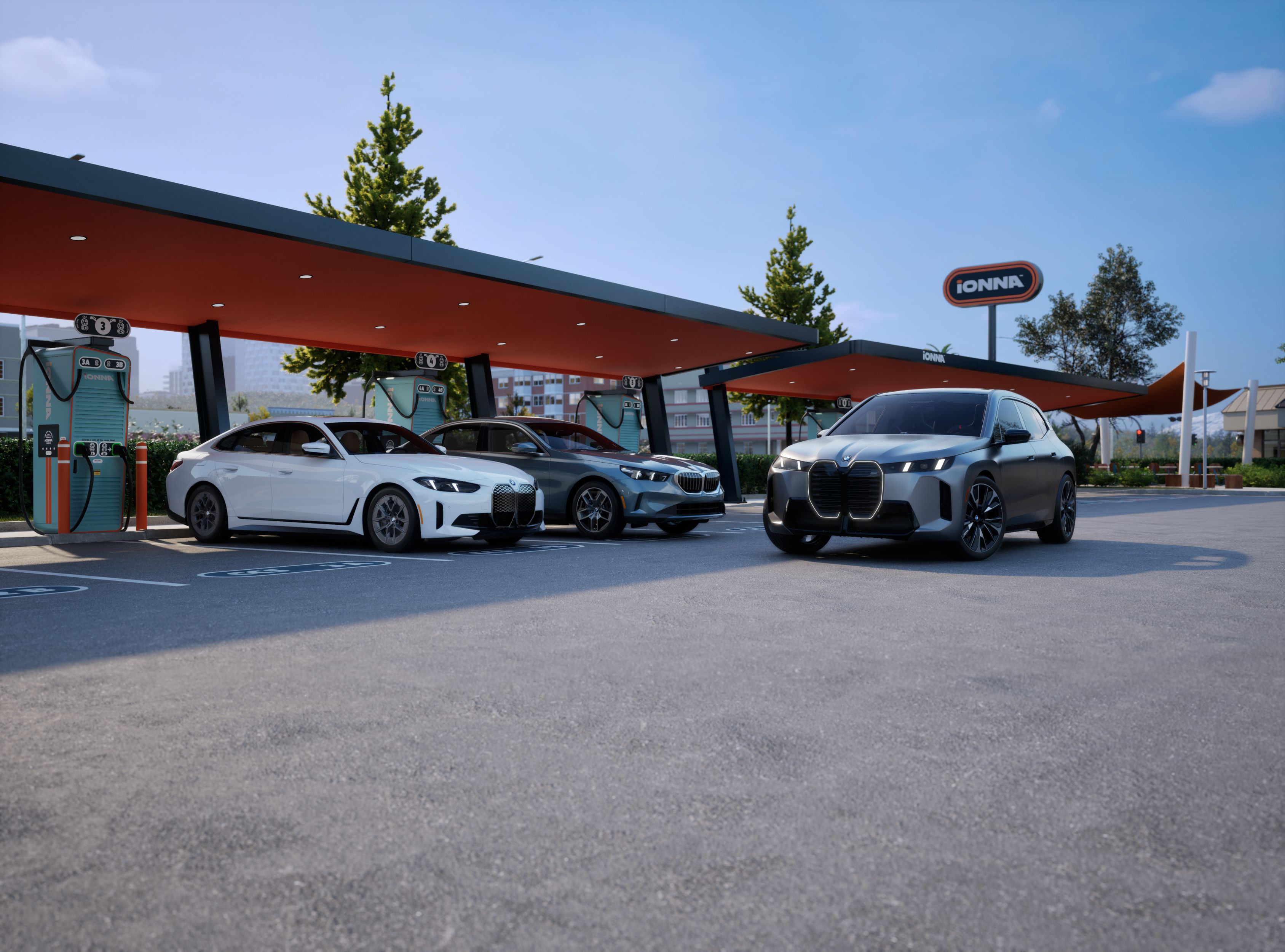 A BMW i4, i5, and iX sit parked at an IONNA charging station