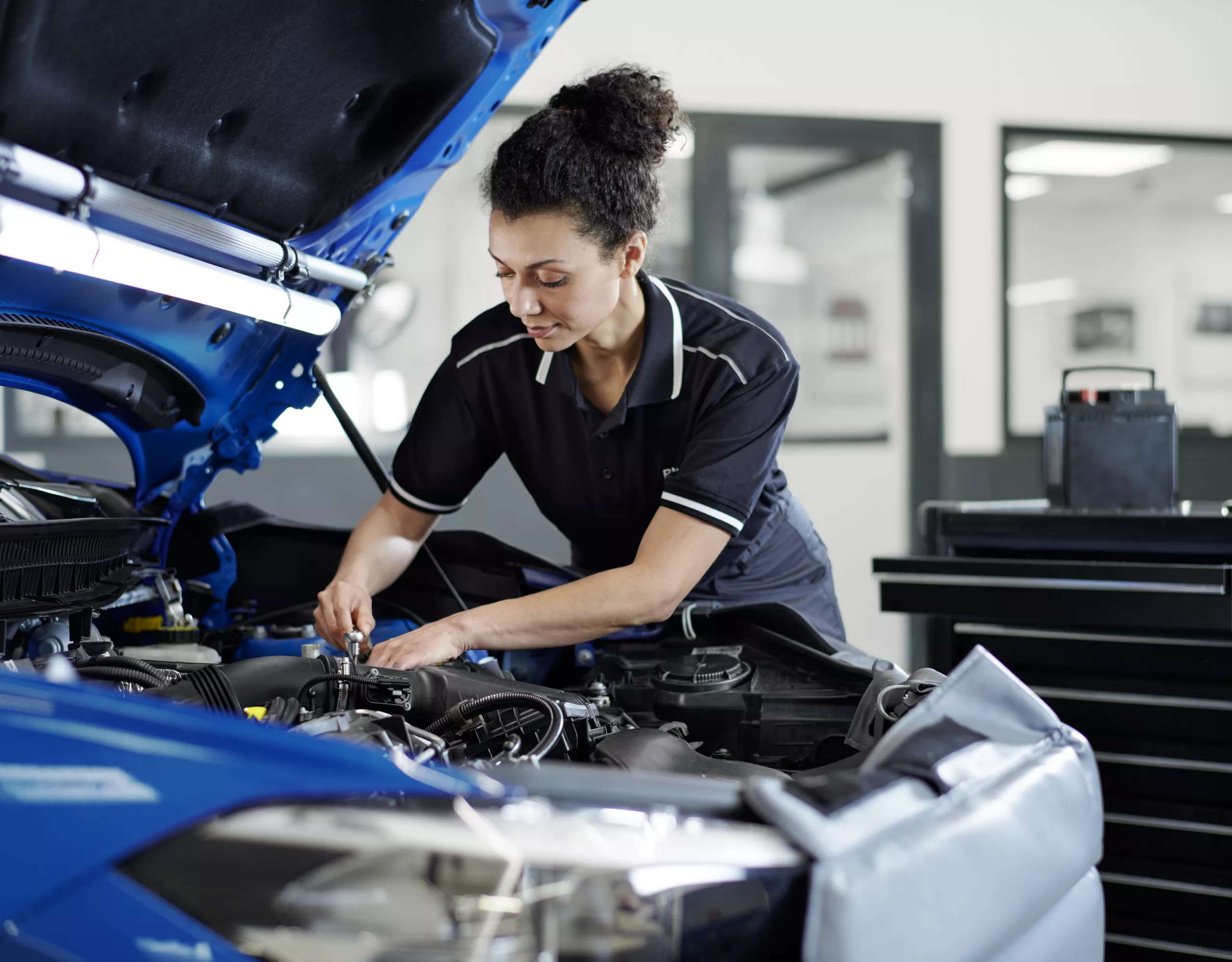 Mujer haciendo mantenimiento de un BMW