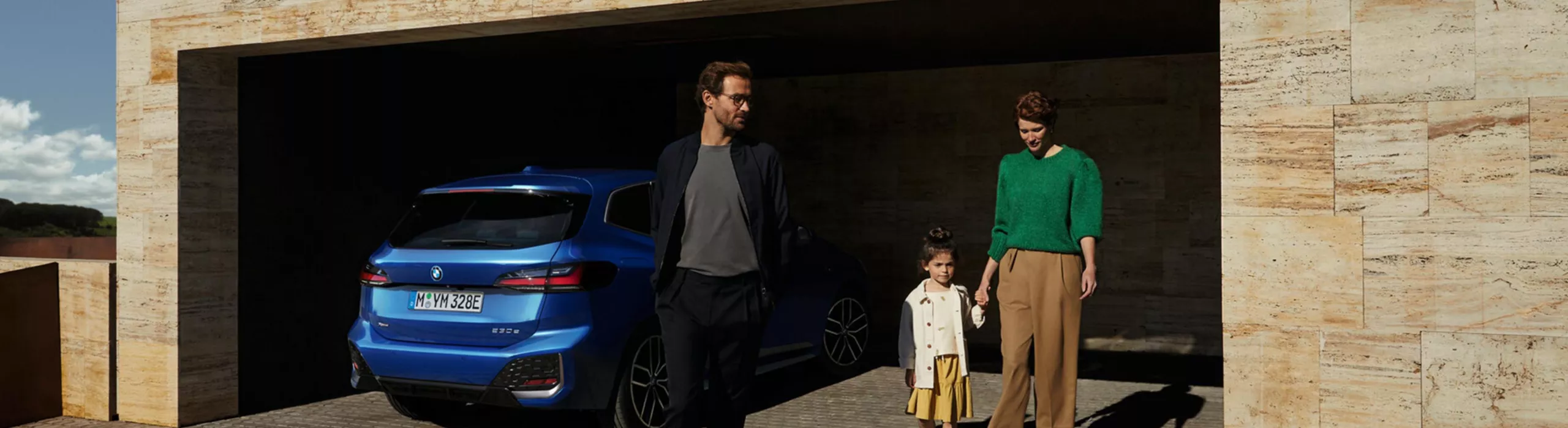 En BMW Active tourer parkerad med människor i bakgrunden.