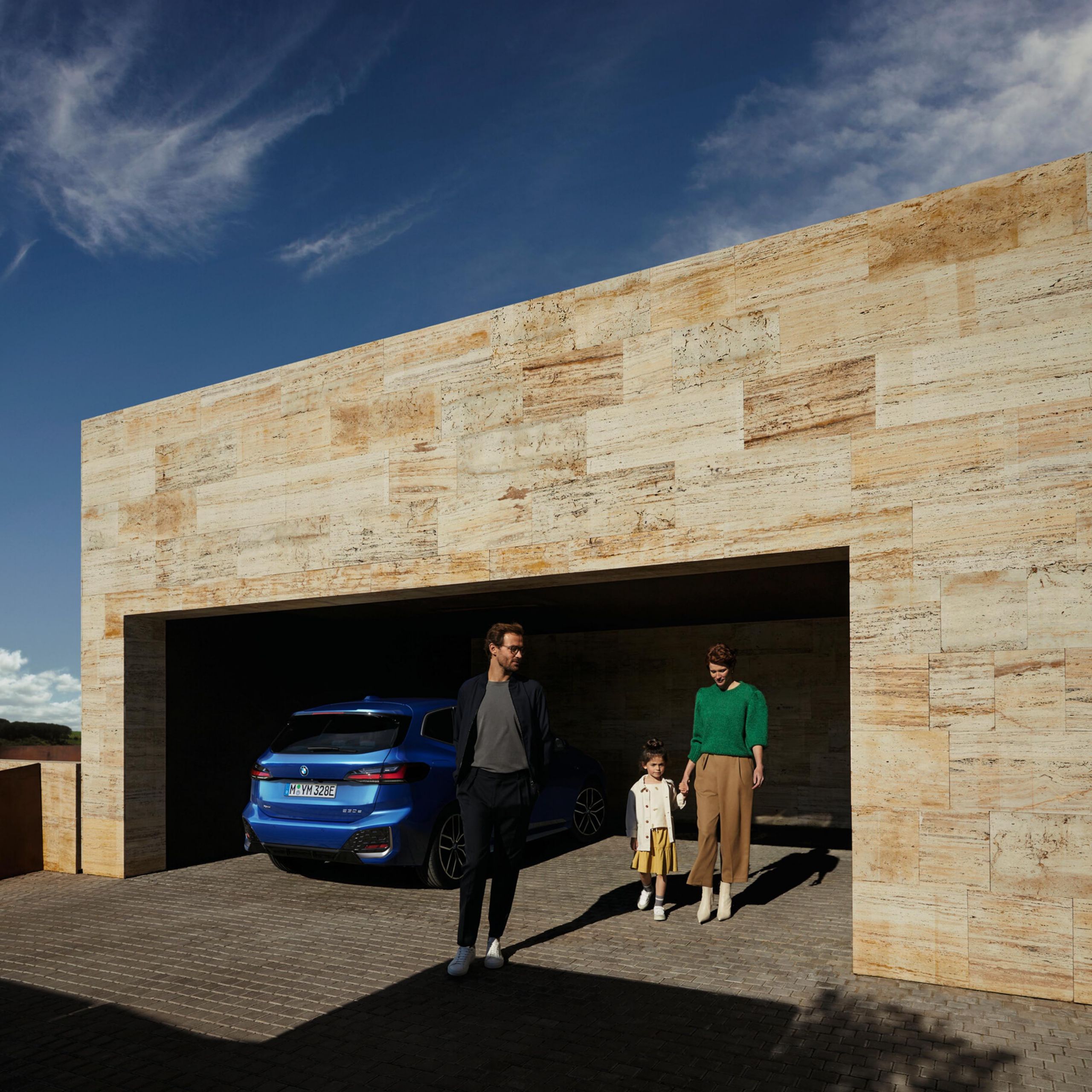 En BMW Active tourer parkerad med människor i bakgrunden.