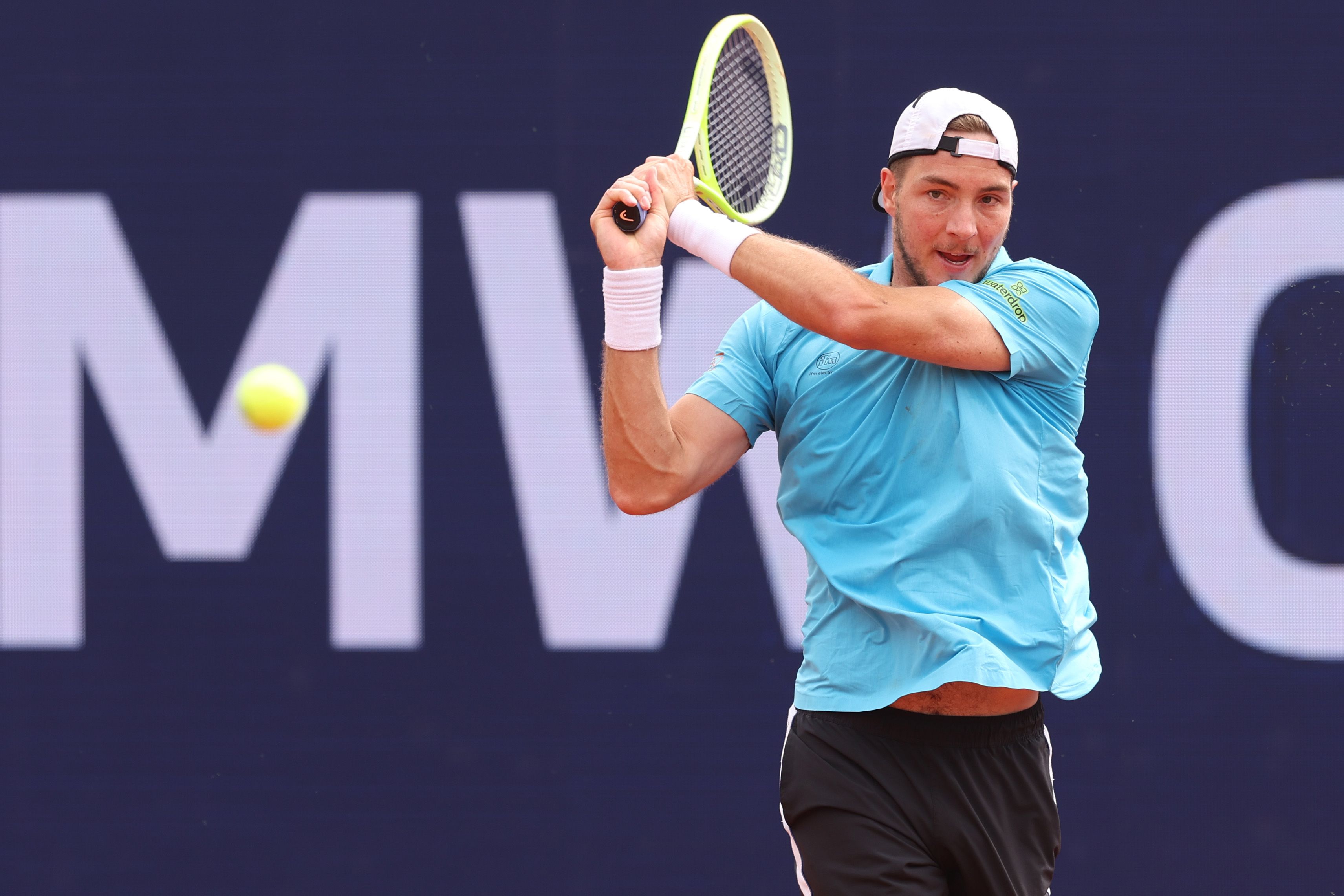 Tennisspieler Jan-Lennart Struff im blauen Shirt schlägt einen Rückhandball während eines Matches.