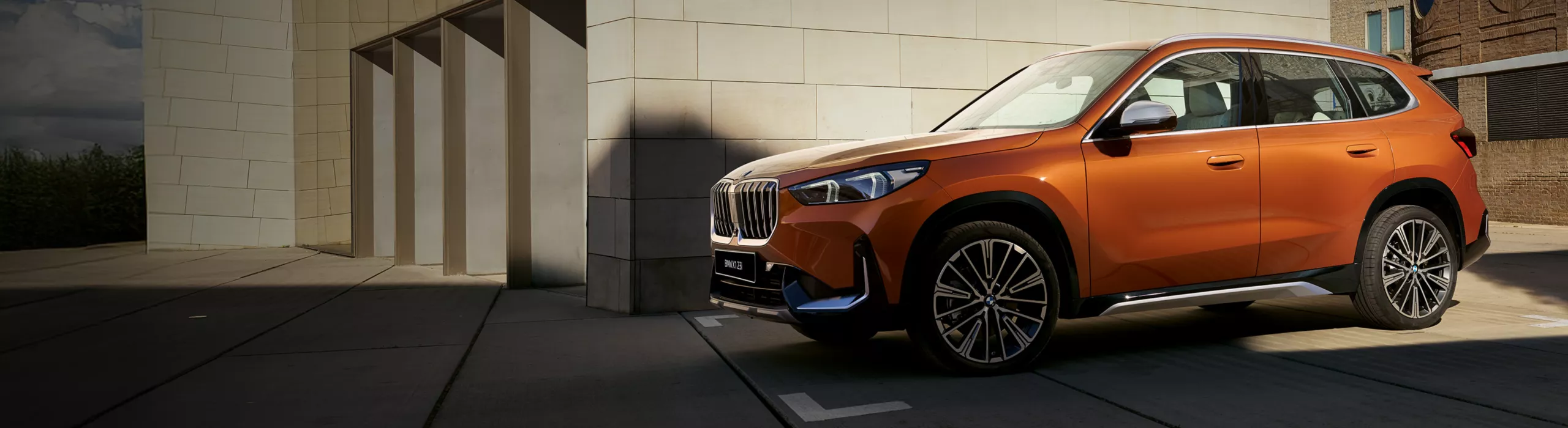 A BMW i3 Sedan is driving on a curvy serpentine road through the mountains