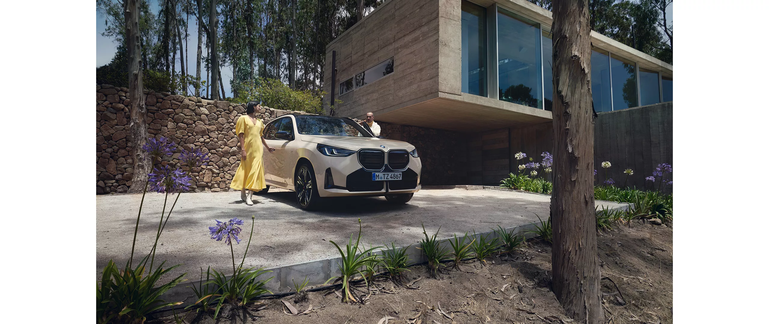 Eine Frau und ein Mann stehen neben einem beigen BMW X3.