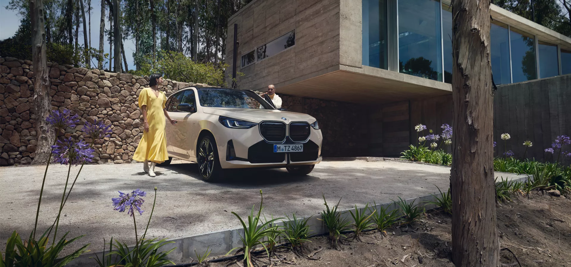 Eine Frau und ein Mann stehen neben einem beigen BMW X3.