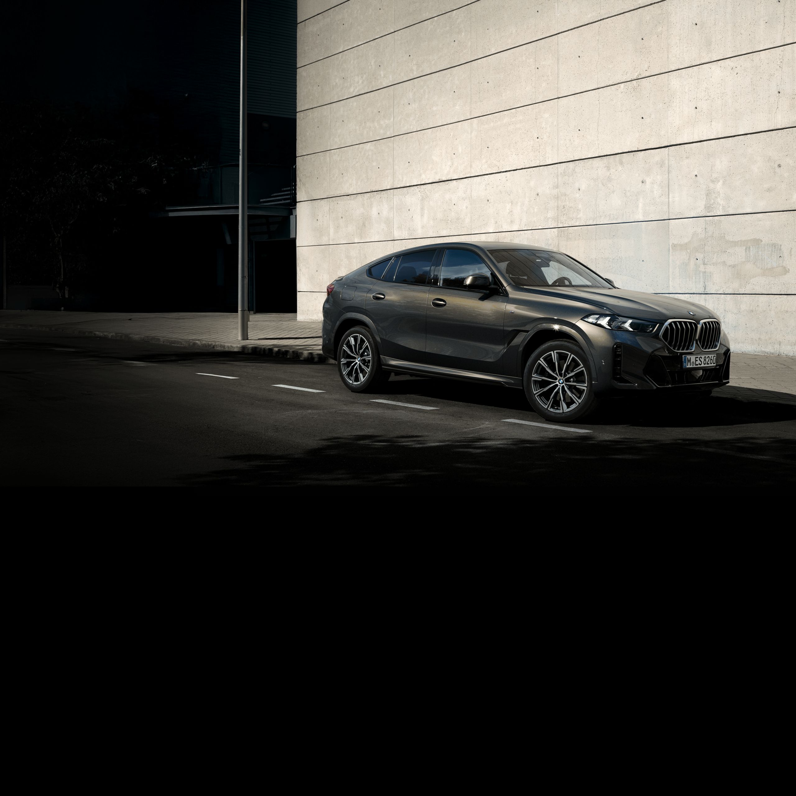 BMW X6が山を背景にして高速道路を走っている。
