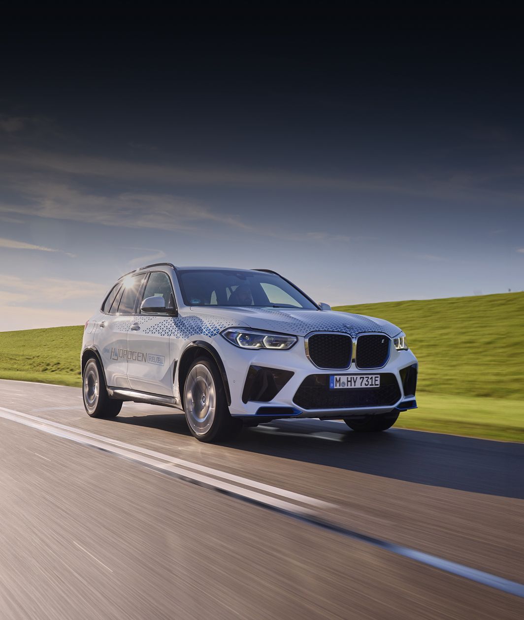 The BMW iX5 Hyrdogen Concept Vehicle driving on a rural highway.