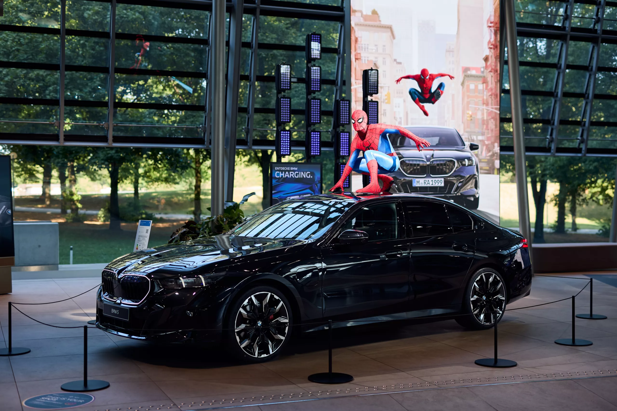 BMW 5 displayed with a Spider-Man figure on the vehicle roof as part of the Spider-Man exhibition at BMW Welt.
