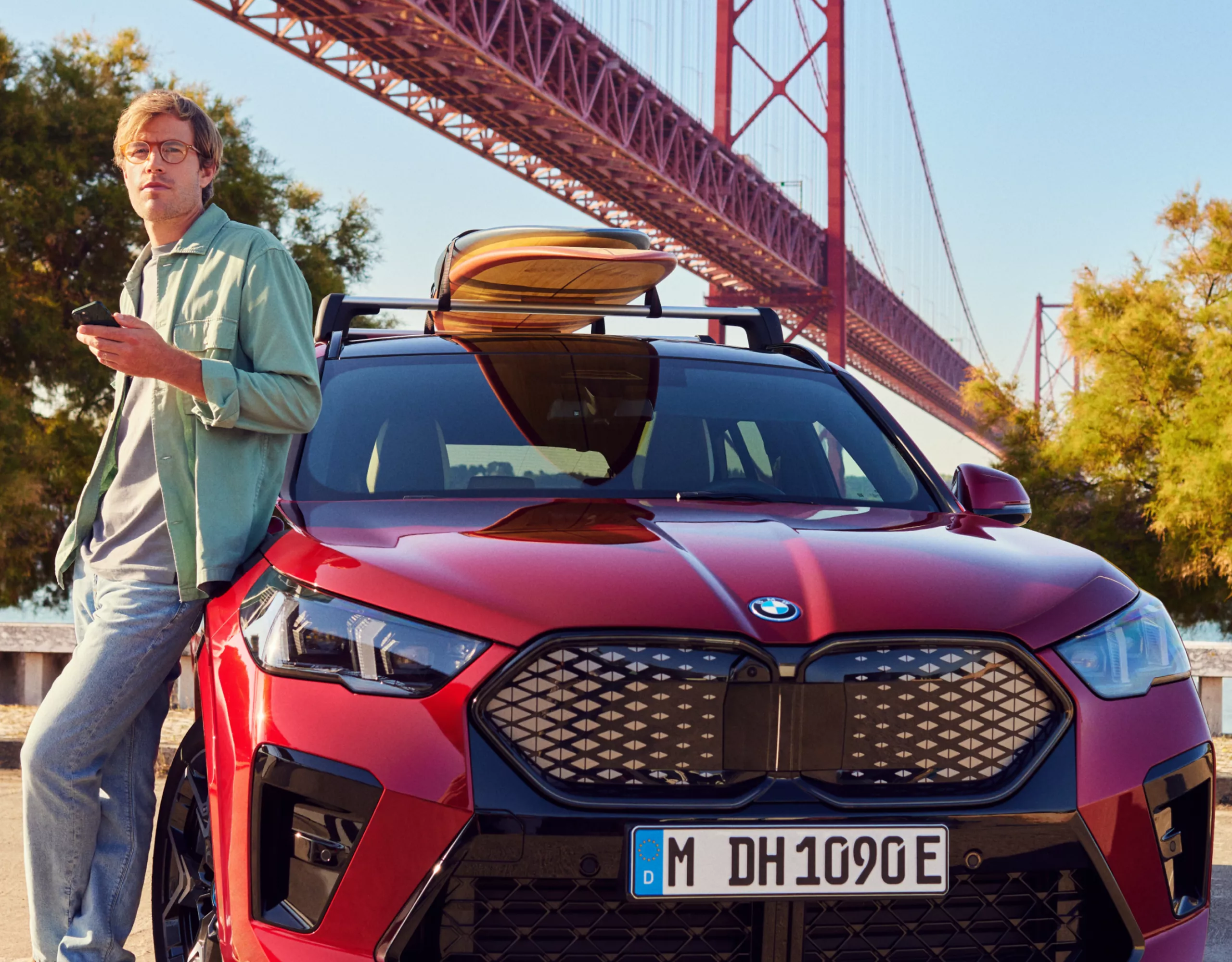 Person lehnt sich an einen BMW vor der Golden Gate Bridge