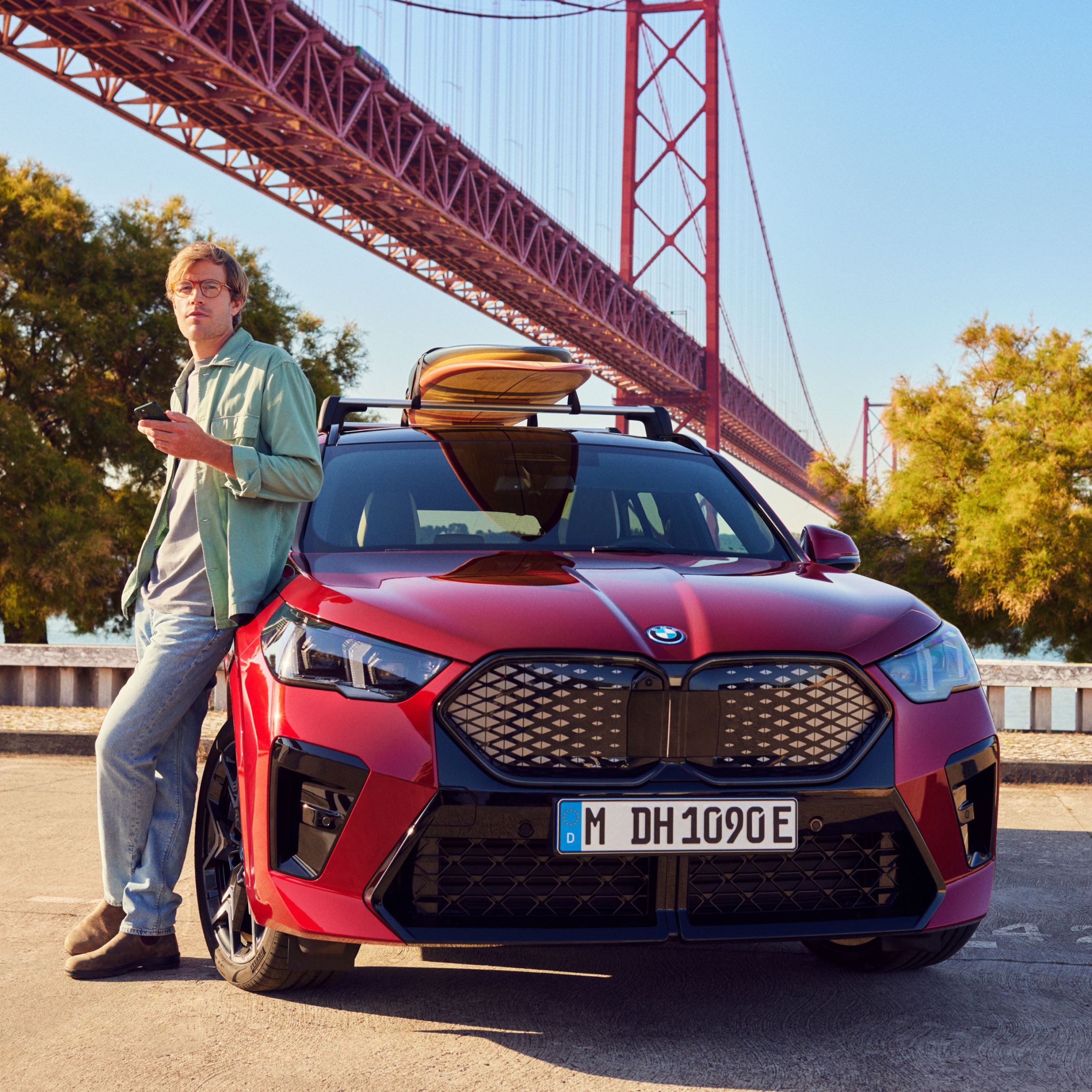 Person lehnt sich an einen BMW vor der Golden Gate Bridge