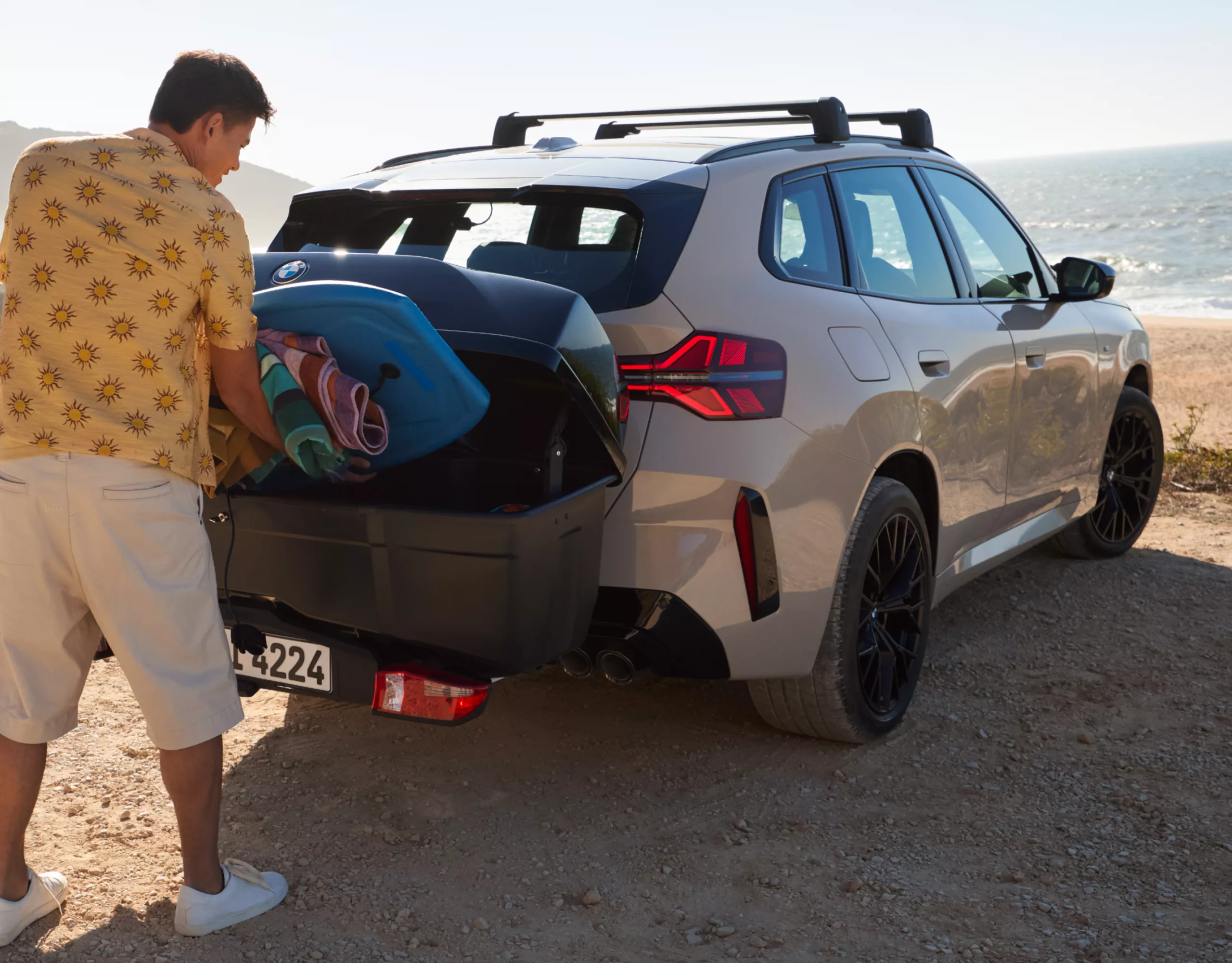Iemand laadt de trekhaakbox in terwijl die op de BMW gemonteerd is
