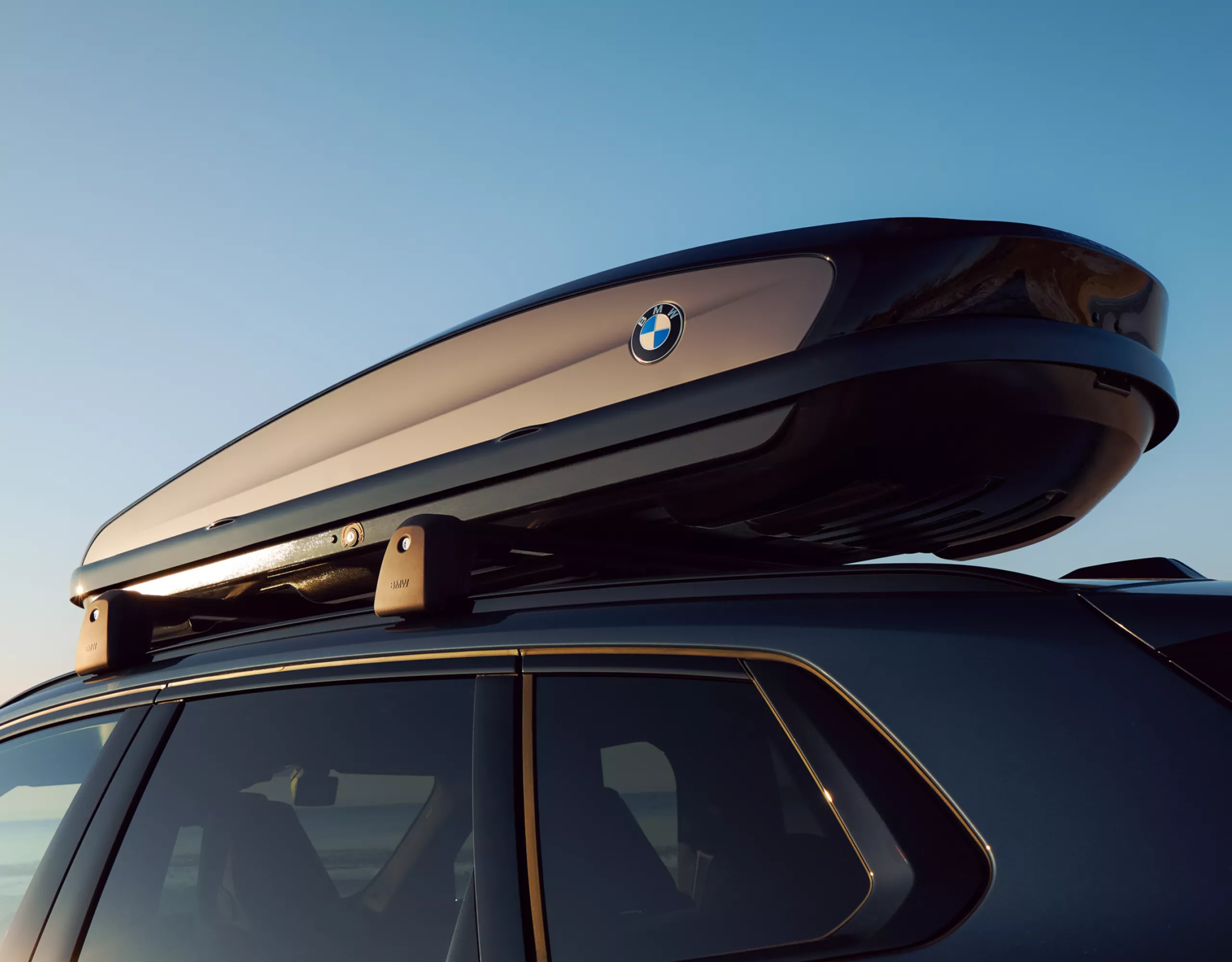 Une BMW avec un coffre de toit sur la plage – vue détaillée du coffre de toit