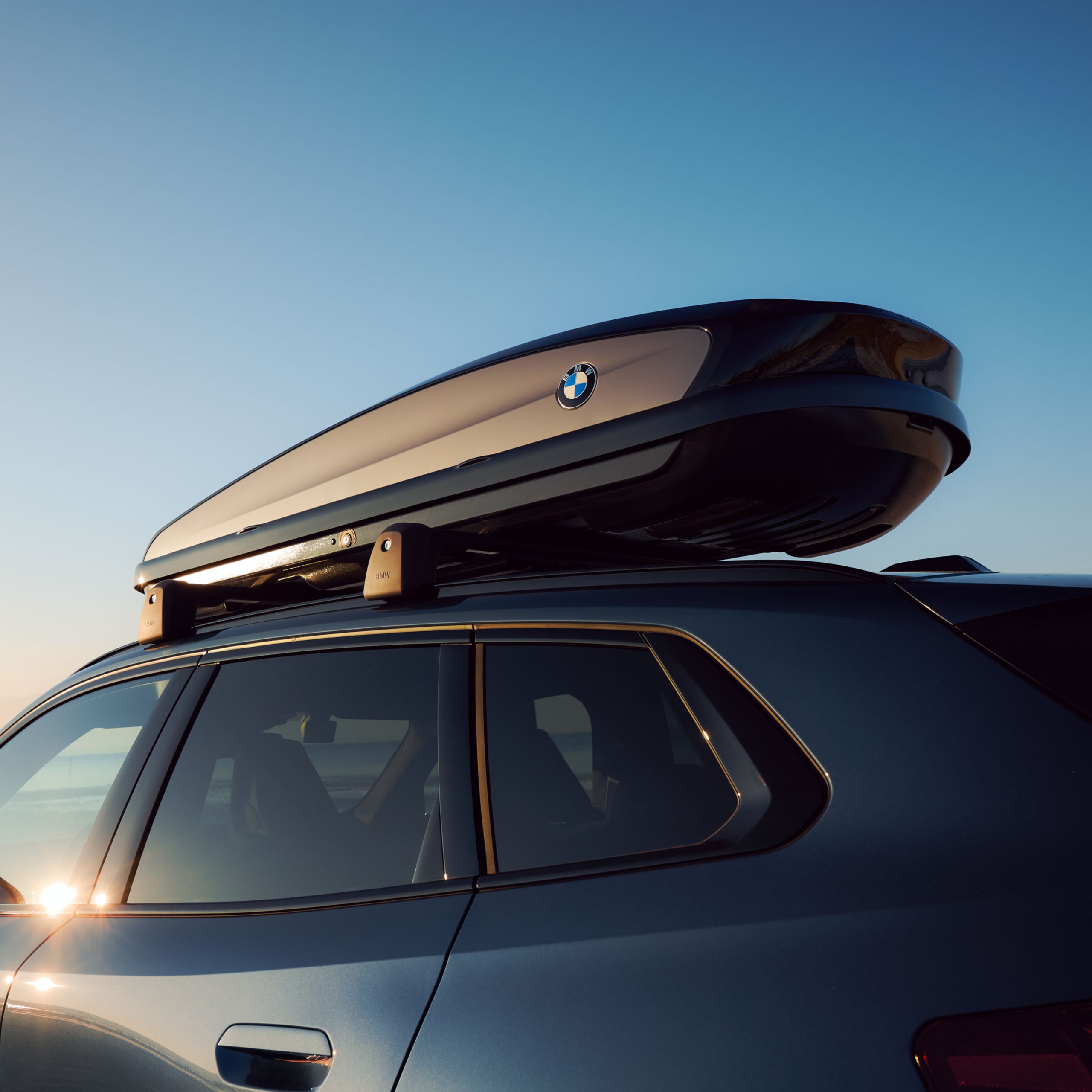 BMW s připevněným střešním boxem stojící na pláži – detailní pohled na střešní box