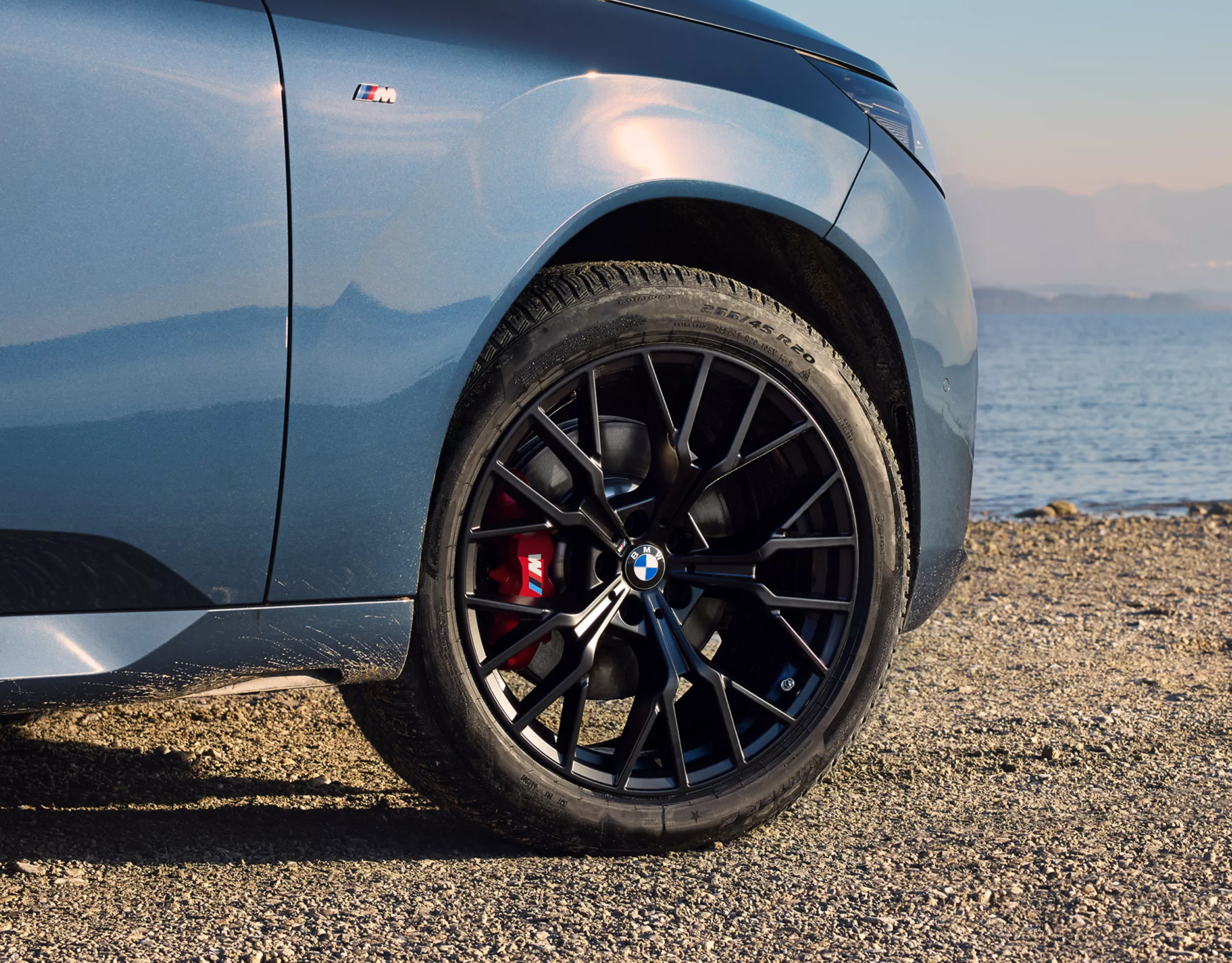 BMW steht auf steinigem Untergrund – Detailansicht des Winter-Komplettrads 20" M Performance Leichtmetallrad Y-Speiche 911 M Jet Black matt