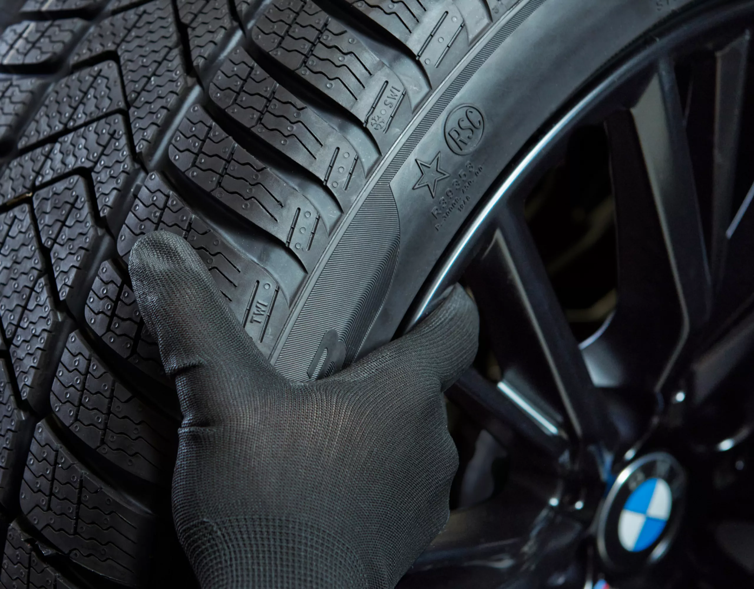 Person hebt BMW Komplettrad hoch