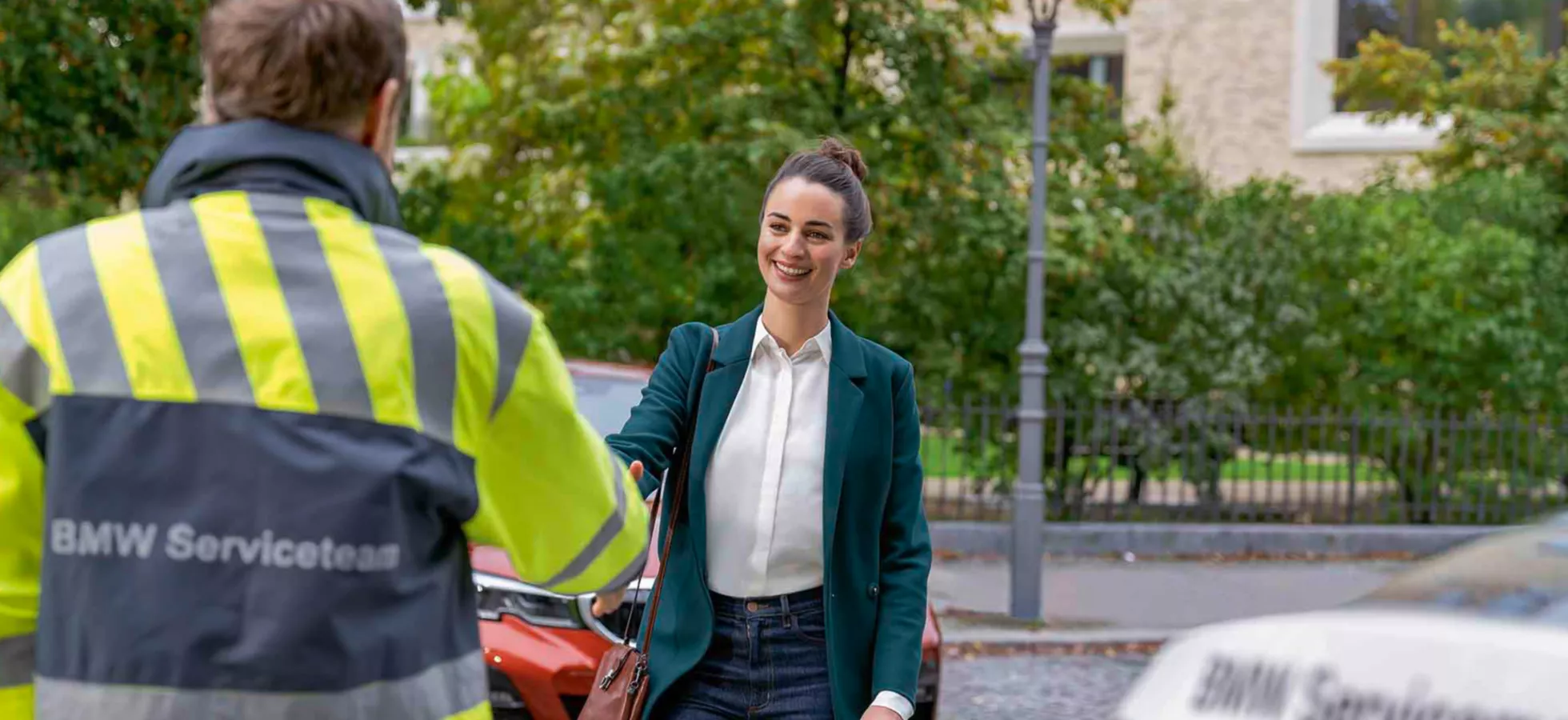 BMW 앞에 서서 스마트폰을 보는 남성