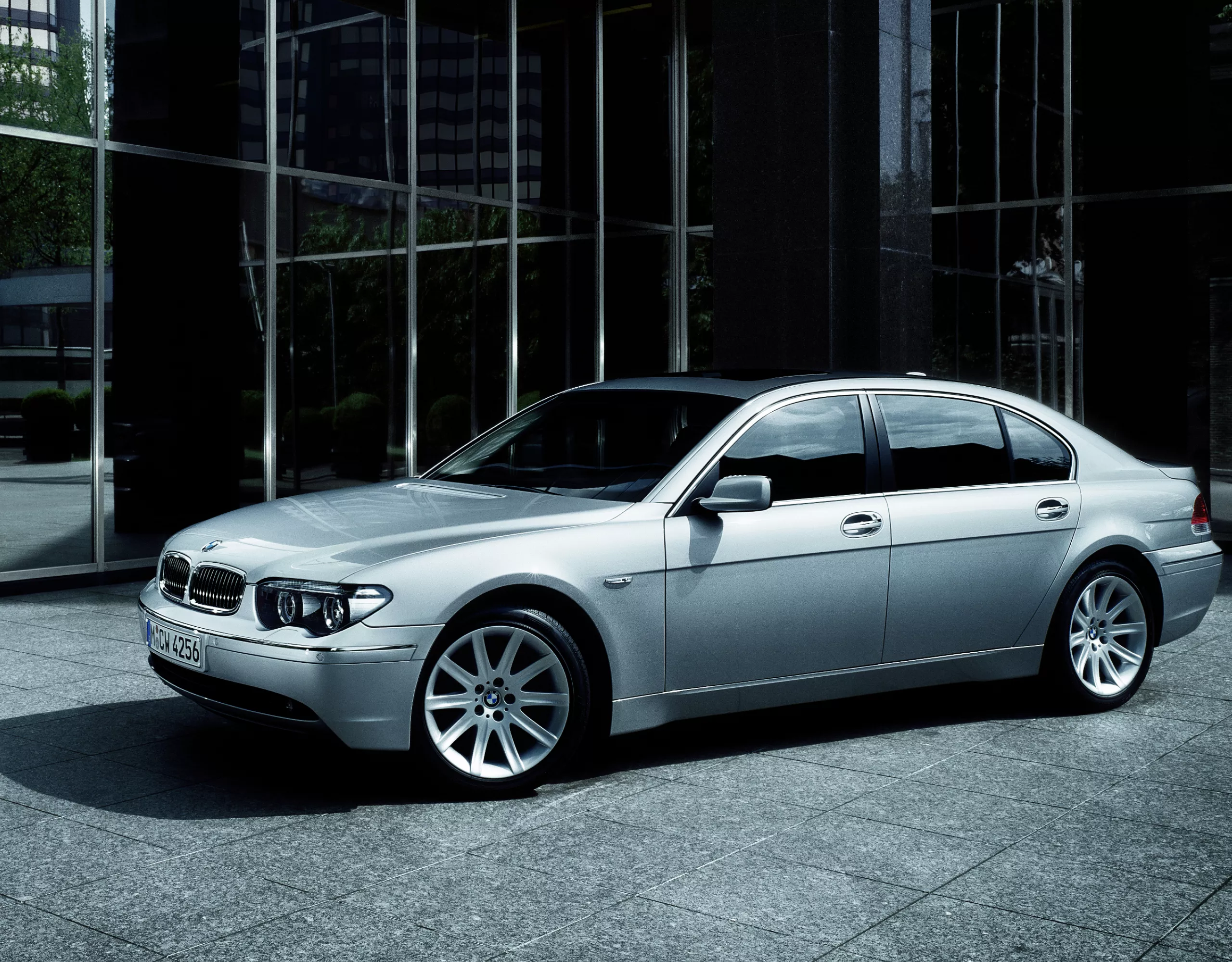 BMW 7er Limousine E65, E66, E67, E68 geparkt vor einem modernen Hochhaus mit einer schwarz getönten Glasfassade 