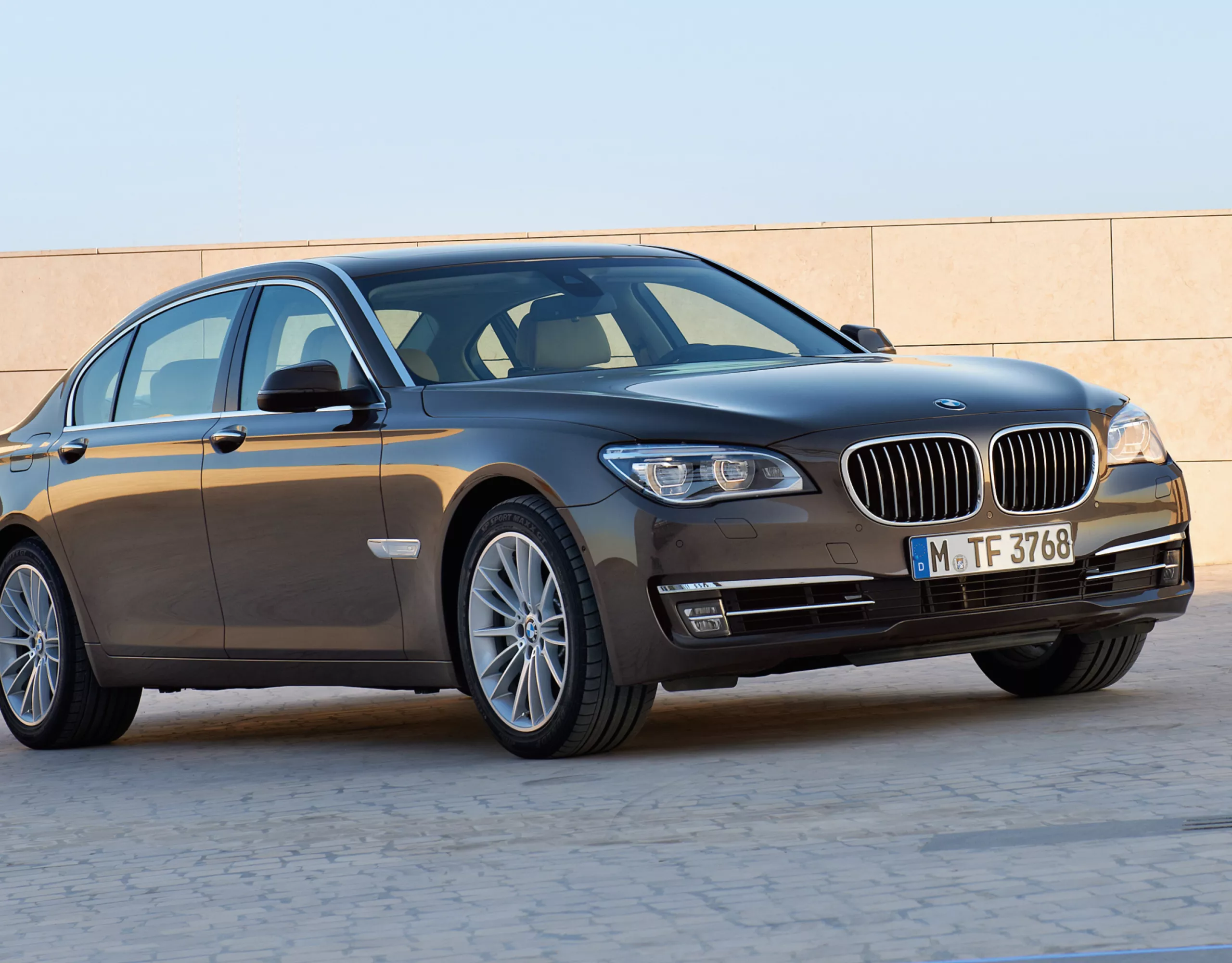 BMW 7er Limousine F01, F02 auf dem Dach eines Parkhauses mit Sonnenschein und blauem Himmel im Hintergrund