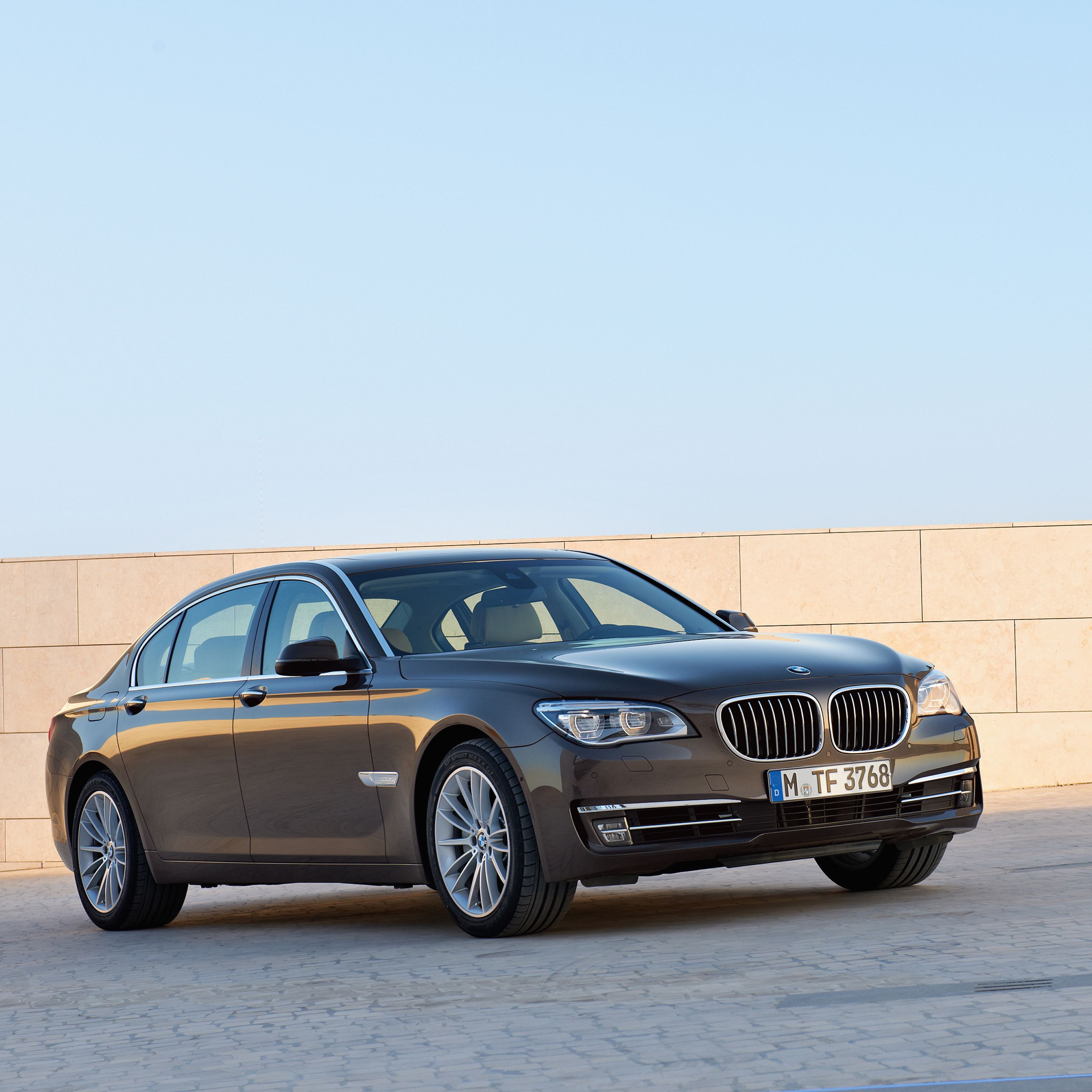 BMW 7 Series Sedan F01, F02 on the roof of a parking garage with sunshine and blue sky in the background