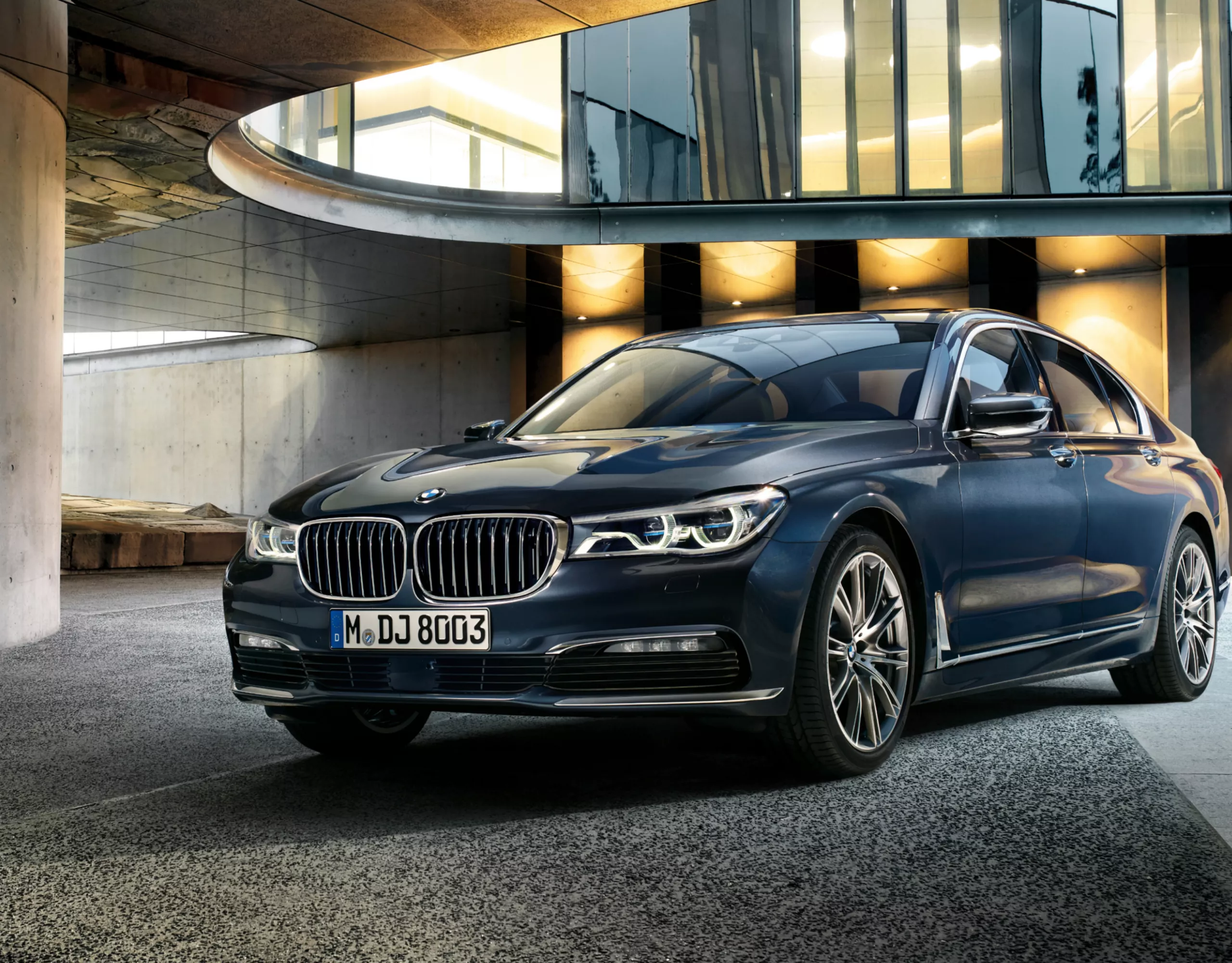 BMW 7er Limousine G11, G12 geparkt in einem Atrium in abendlicher Kulisse mit warmen Lichtern im Hintergrund