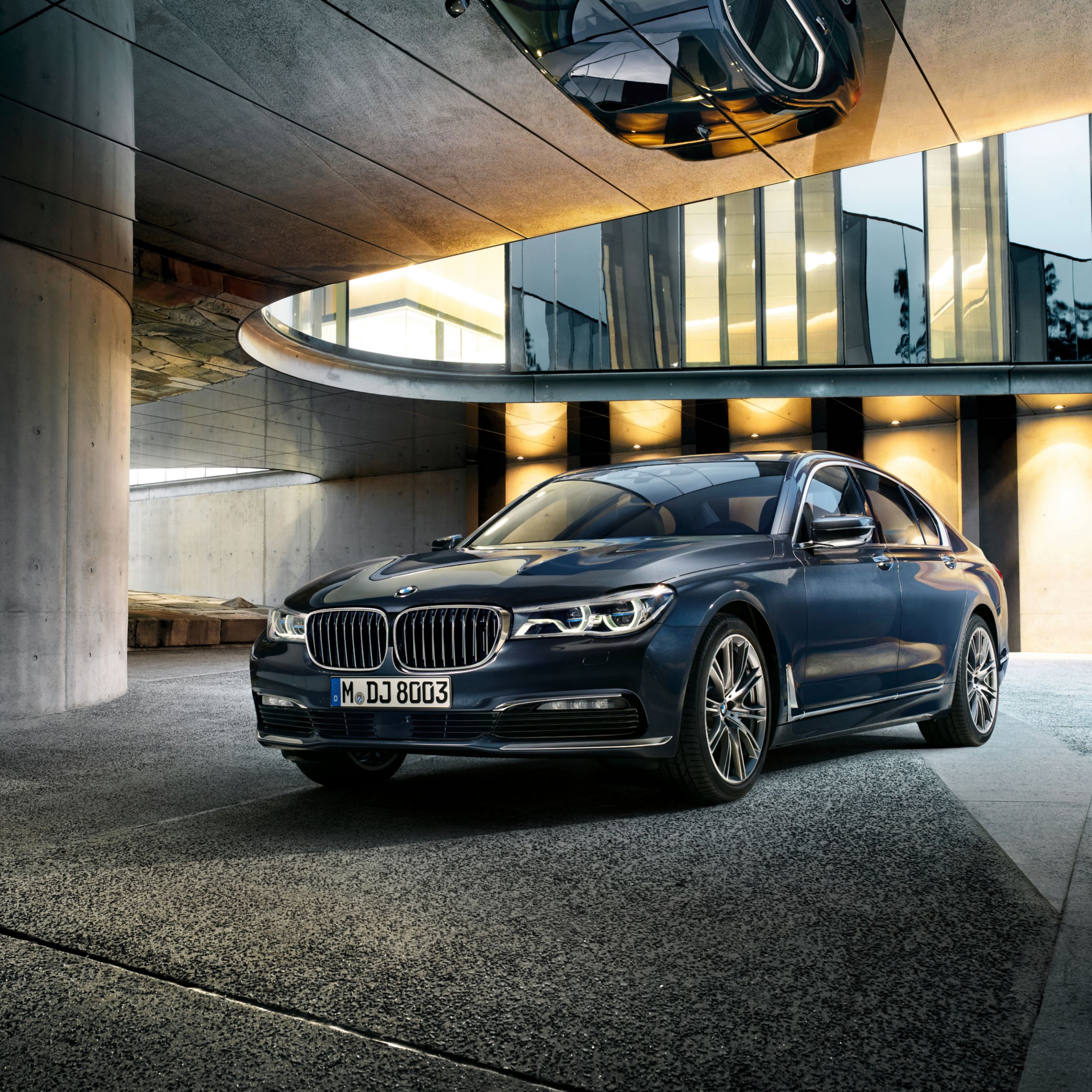 BMW 7 Serie Sedan G11, G12 in een atrium tegen een nachtelijk decor met warme verlichting op de achtergrond
