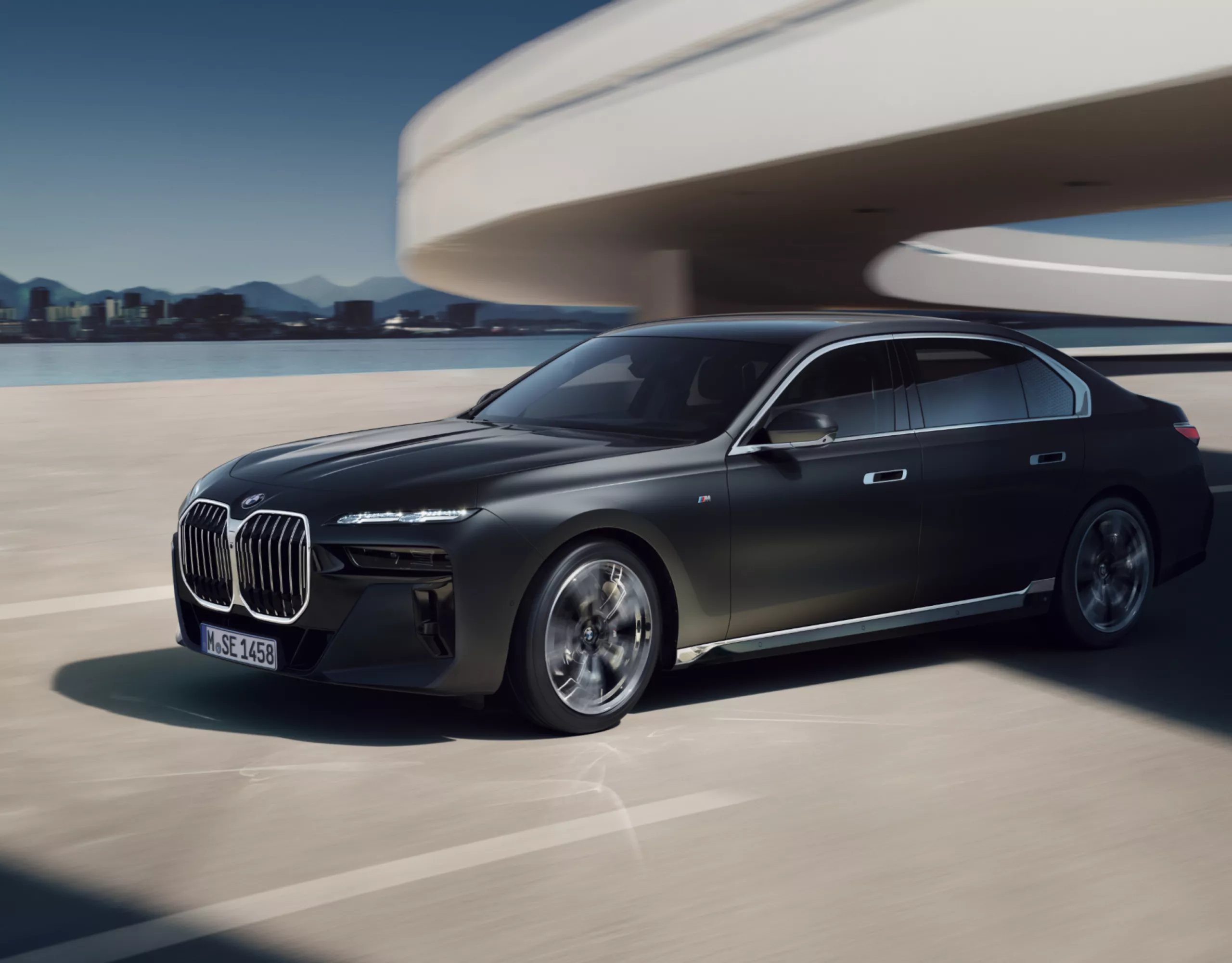 BMW 7er Limousine G70 fahrend auf einer futuristischen Autobahn mit Stadtpanorama im Hintergrund
