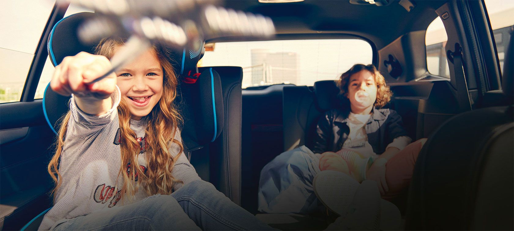 Kids playing in back of BMW vehicle. 