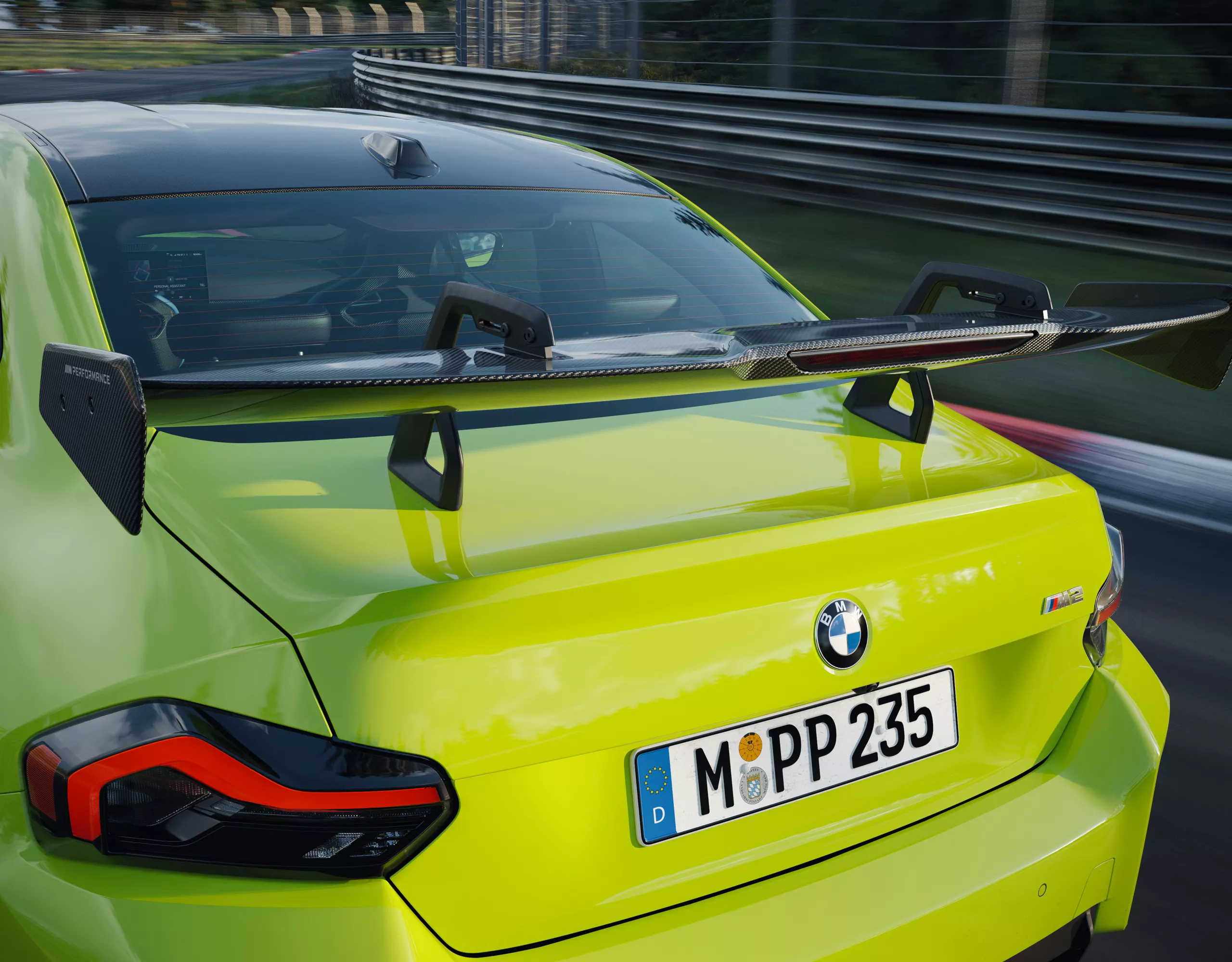 M Performance karbon hátsó szárny egy versenypályán haladó BMW M2 hátsó részén