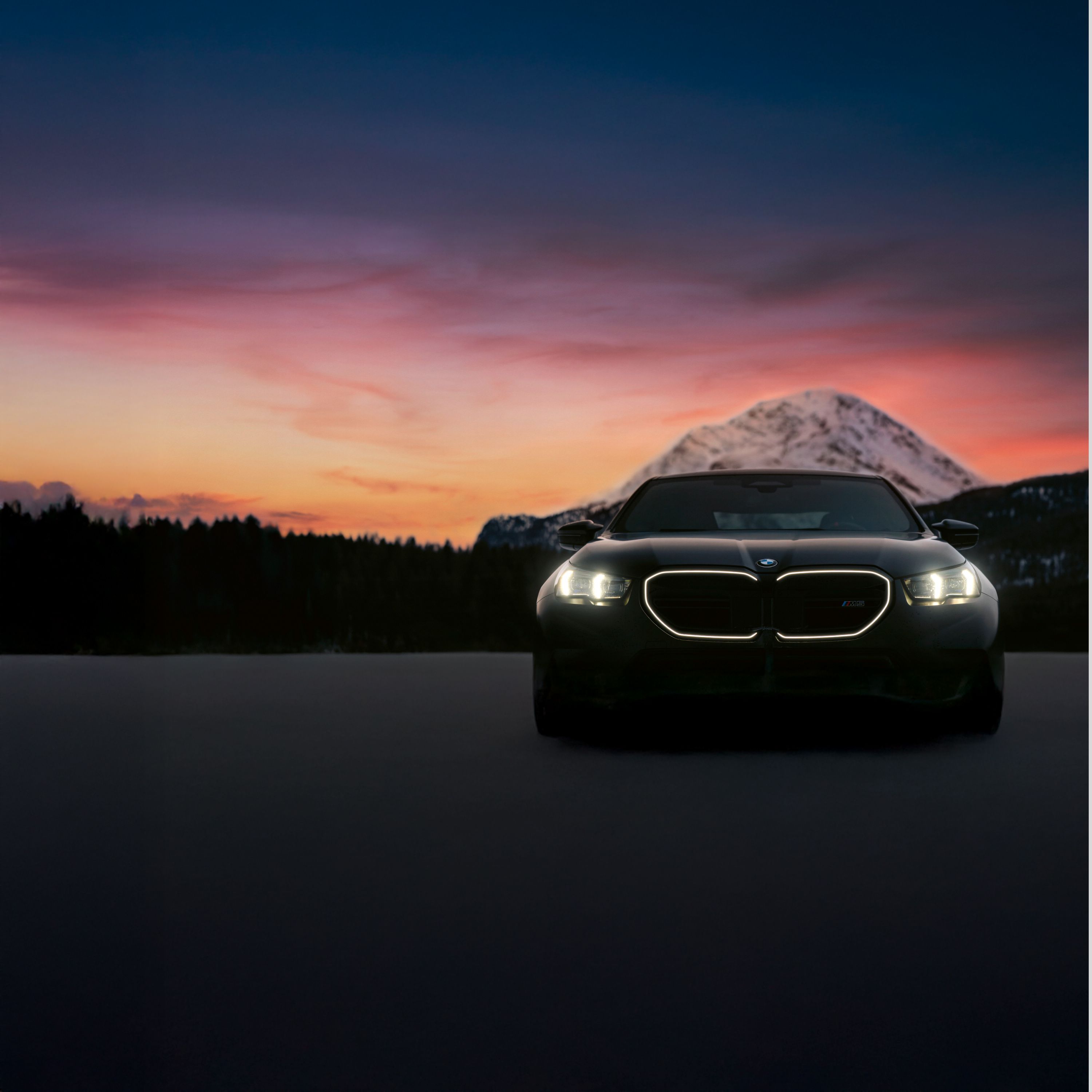 Die beleuchtete BMW Niere steht im Fokus bei einem insgesamt sehr dunklen Hintergrund 