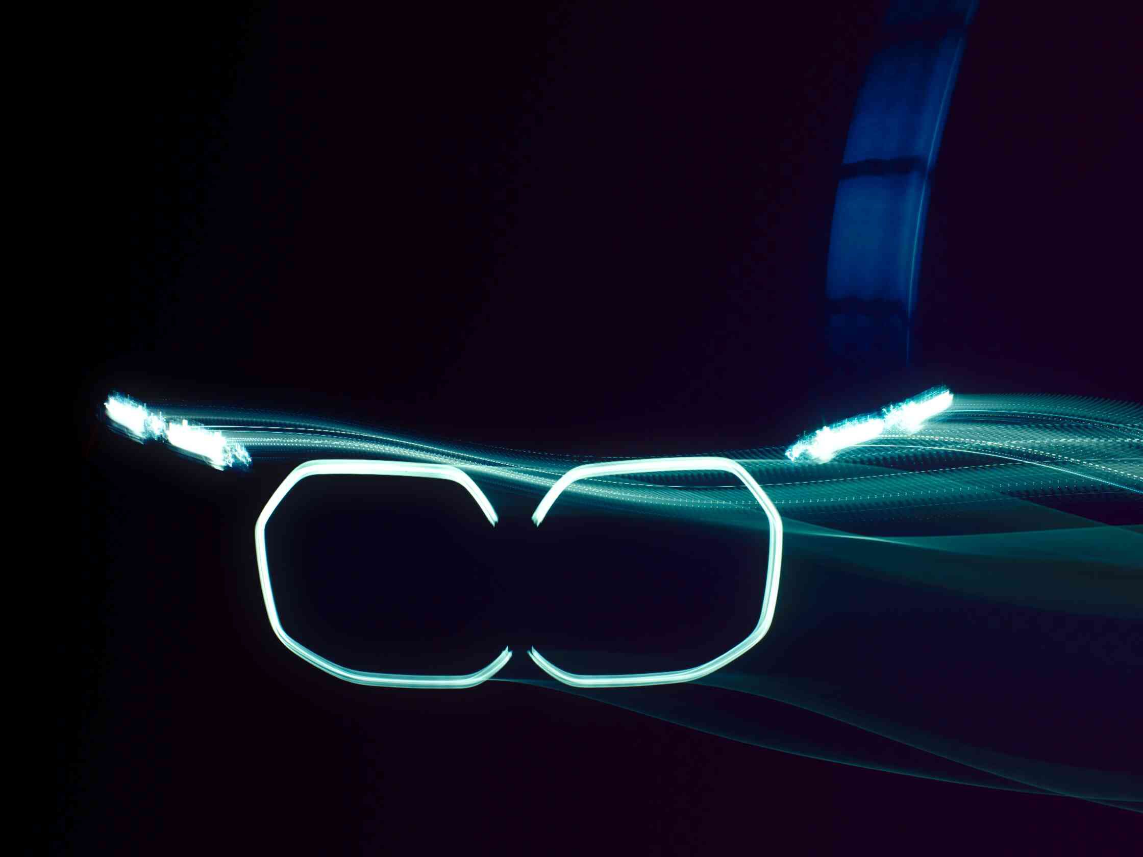Gros plan frontal de la calandre à double haricot et des phares cristal BMW Iconic Glow allumés dans l’obscurité