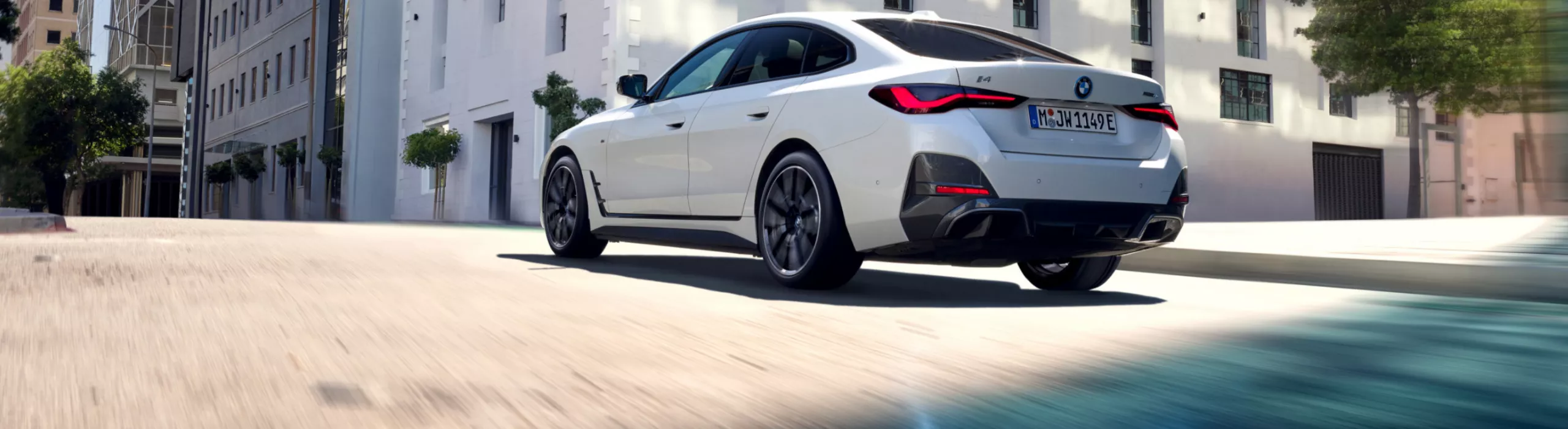 Une BMW roule sur une route en ville. Vue en contre-plongée de l’arrière