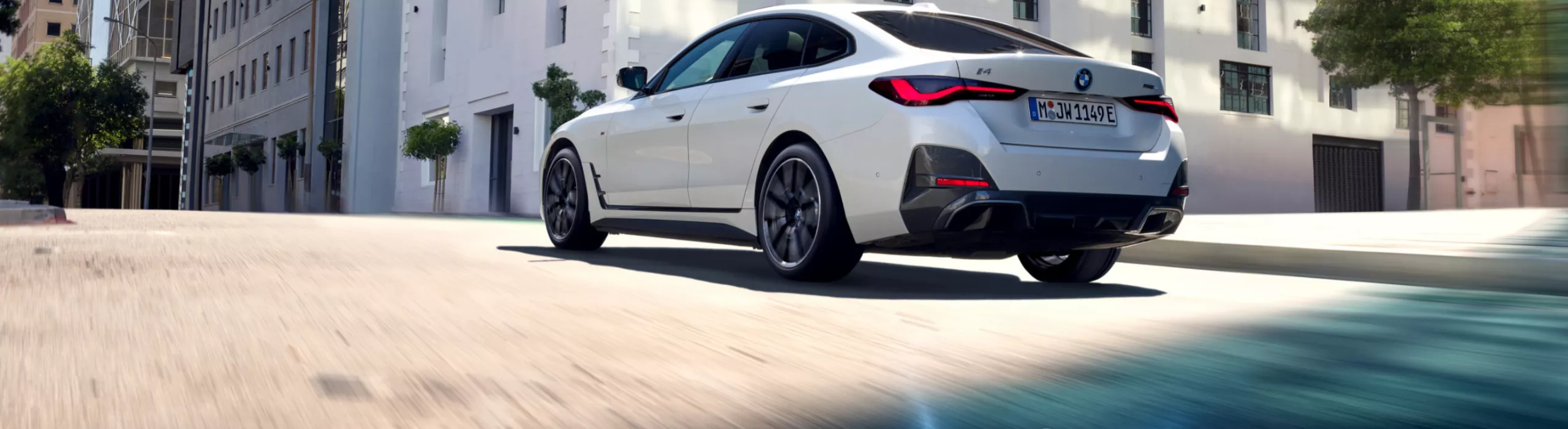 BMW percorre una strada in città. Inquadratura dal basso da dietro