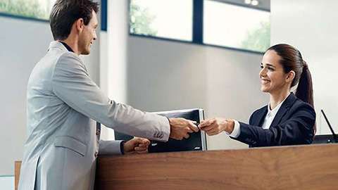 BMW ConnectedDrive Customer Support BMW service employee hands over the key to customer