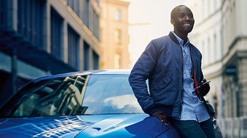 BMW Financial Services, άντρας στηρίζεται επάνω σε μία BMW