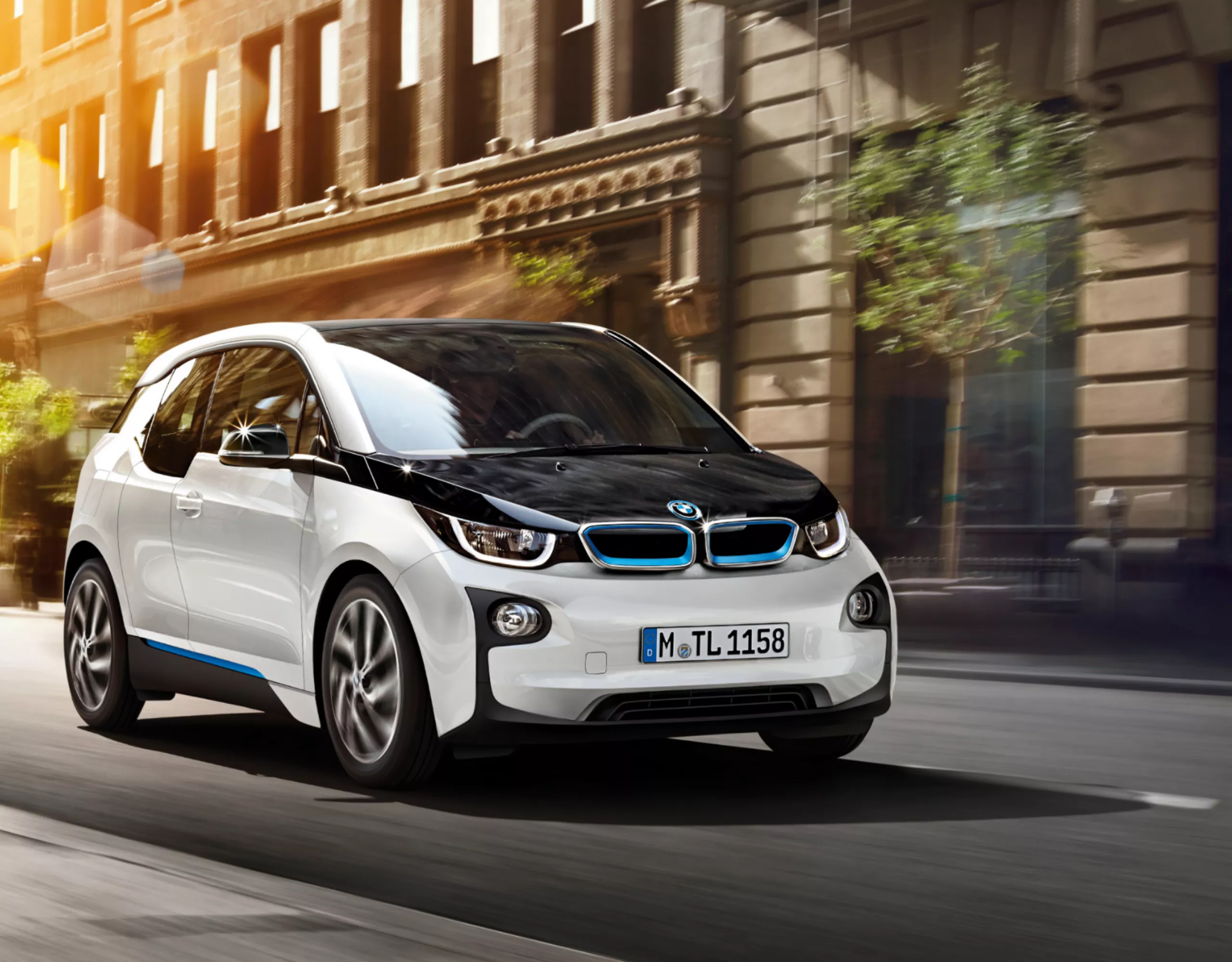 Véhicule compact électrique blanc BMW i3 en état de marche devant une architecture romaine